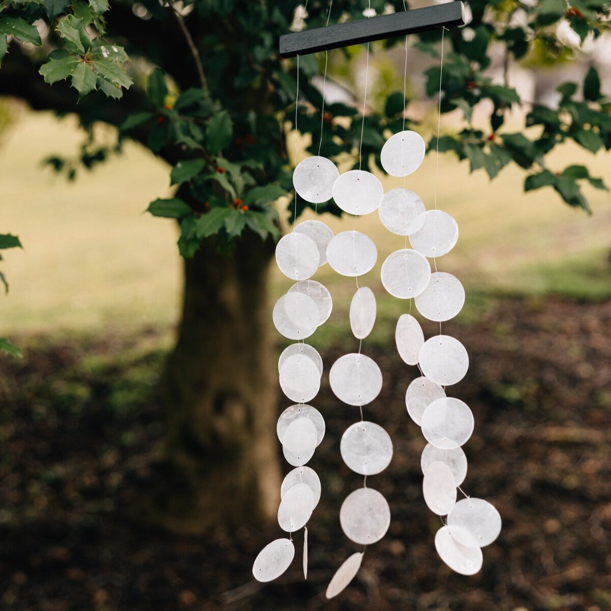 Close-up of Serene Melody Artisan Wind Chimes showcasing capiz shells swaying in a gentle breeze.