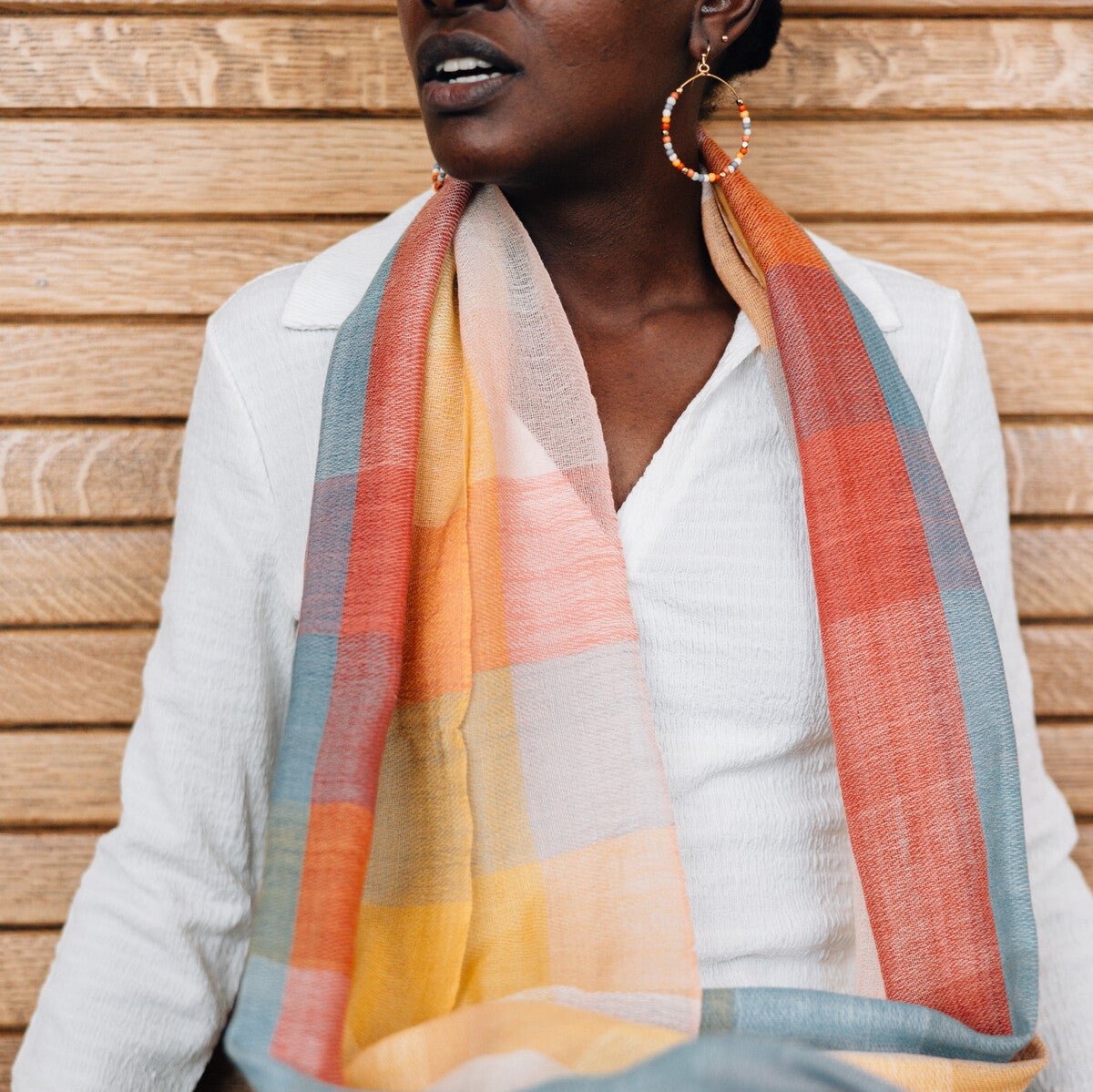 Close-up of the vibrant plaid wool scarf highlighting its merino wool texture.