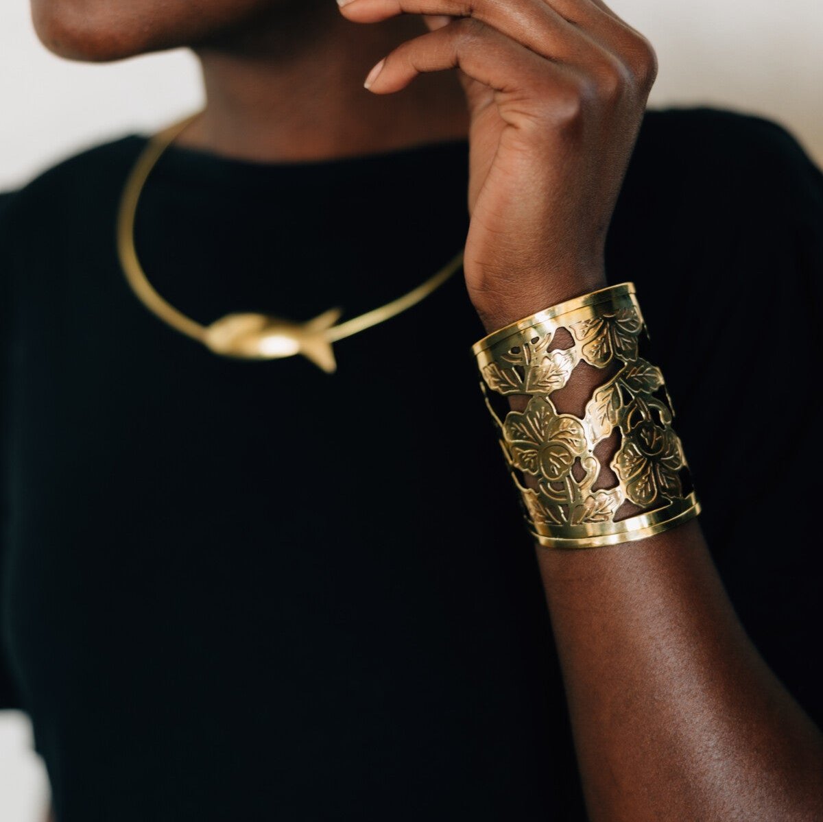 Elegant floral cuff bracelet showcasing a detailed embossed design from a side angle.