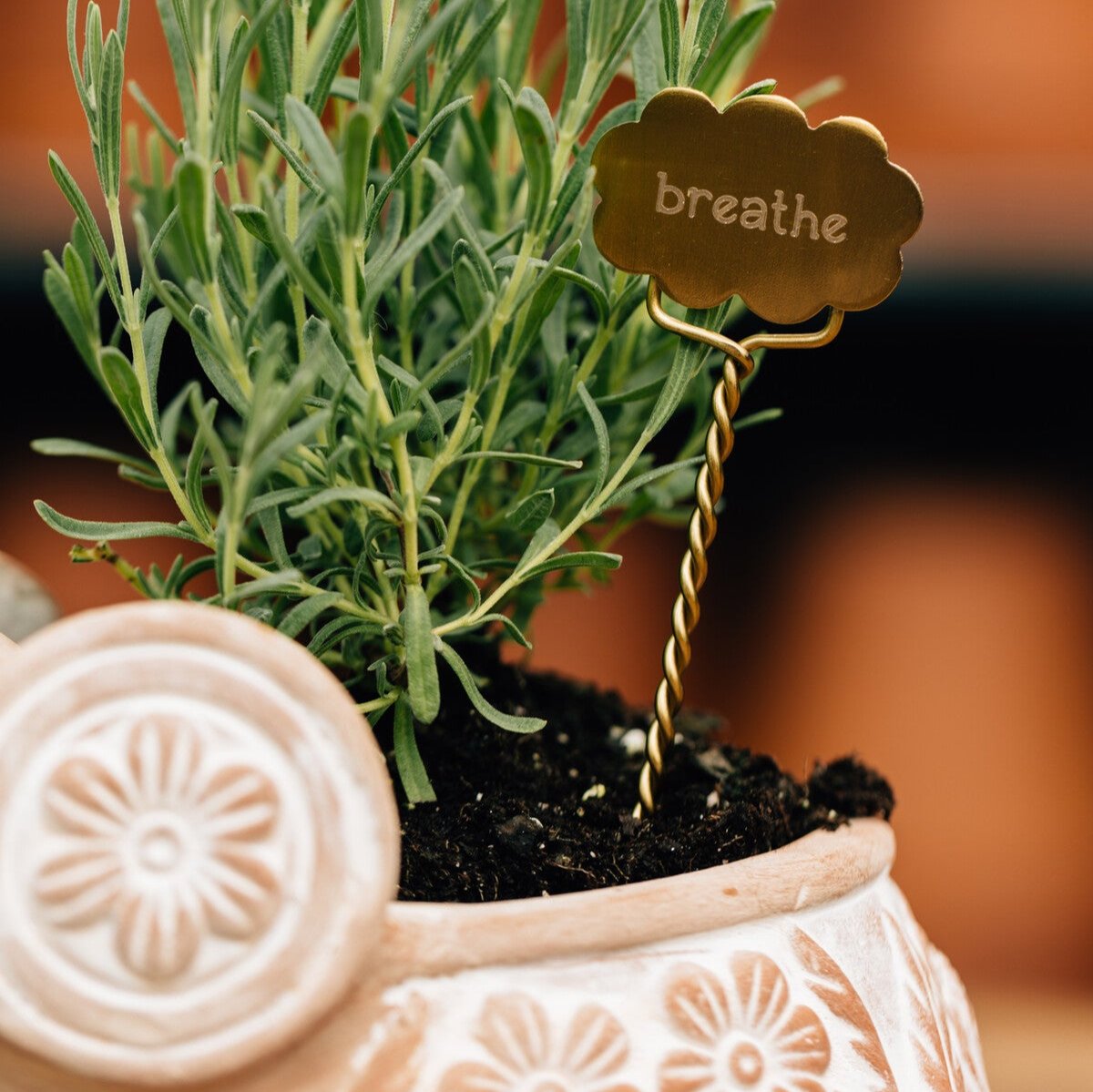 Close-up of handcrafted plant labels with intricate designs for herbs and pots