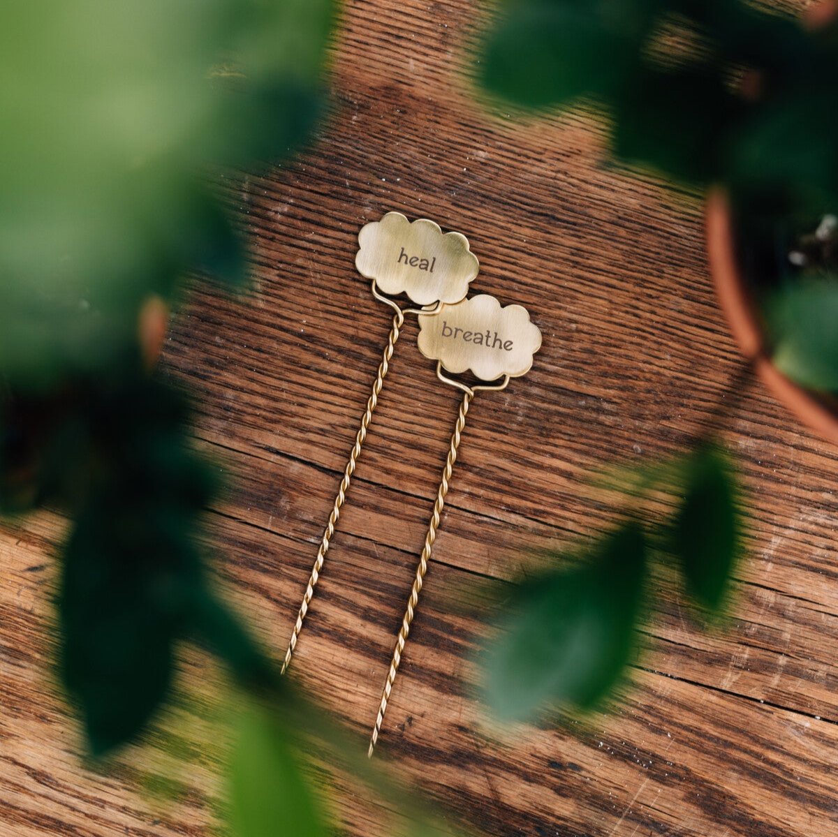 Close-up of handcrafted plant labels with intricate designs for herbs and pots