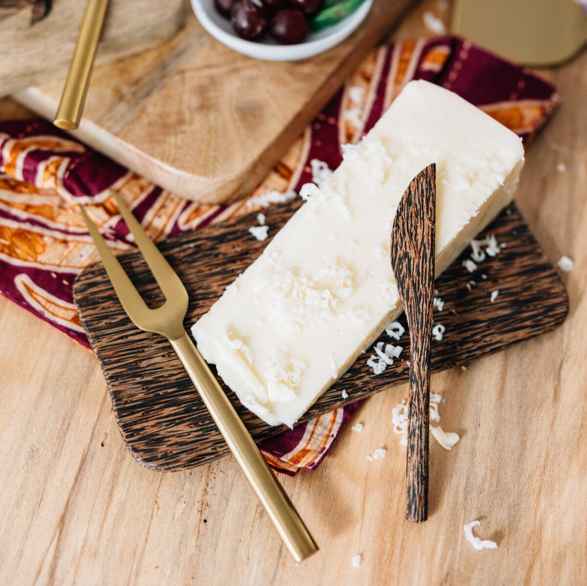 Elegant cheese tray set up with red grapes, nuts, and honey, ideal for any gathering.