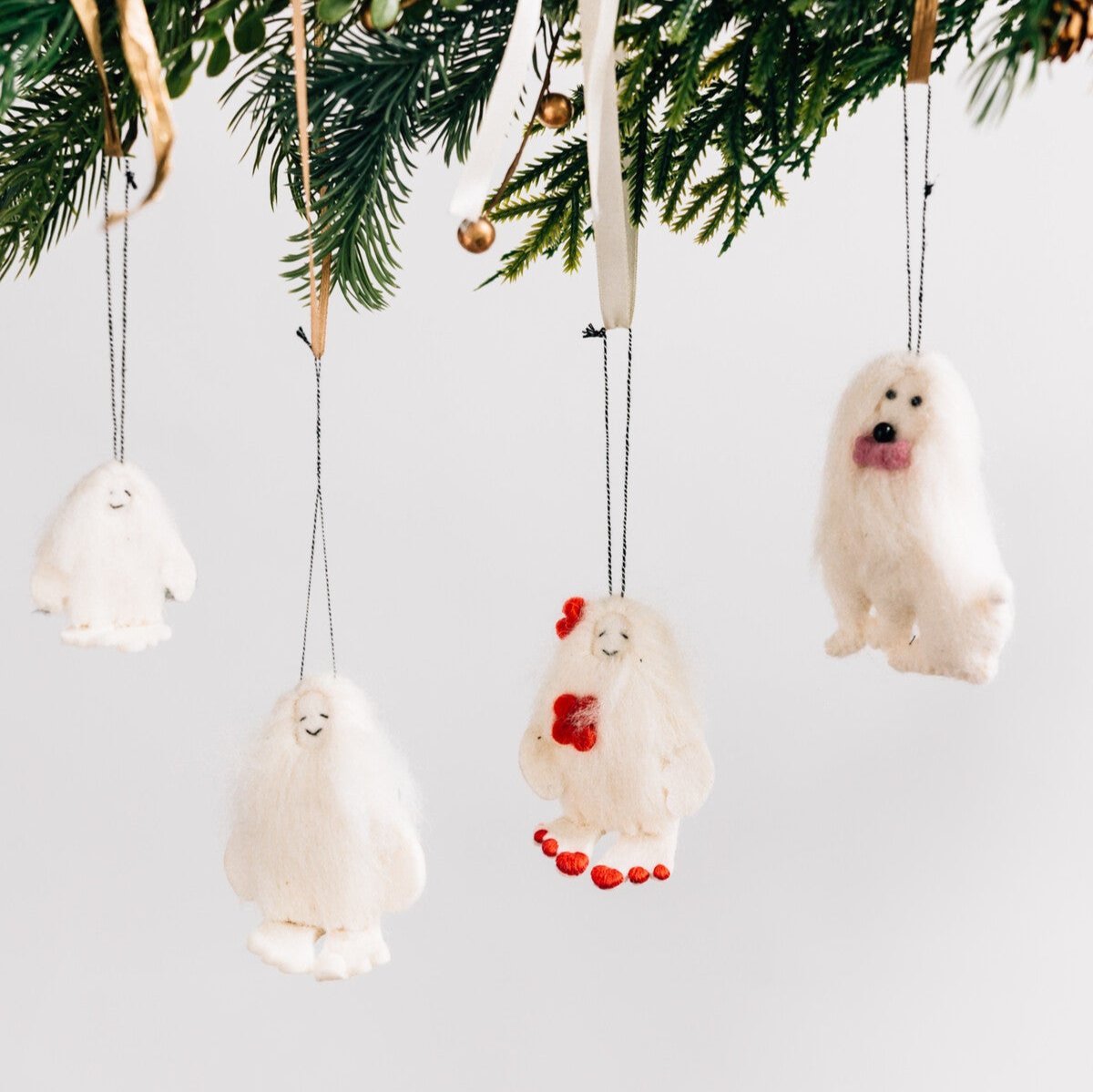 Close-up of the felt dog ornament showcasing the pink bowtie and beaded eyes.