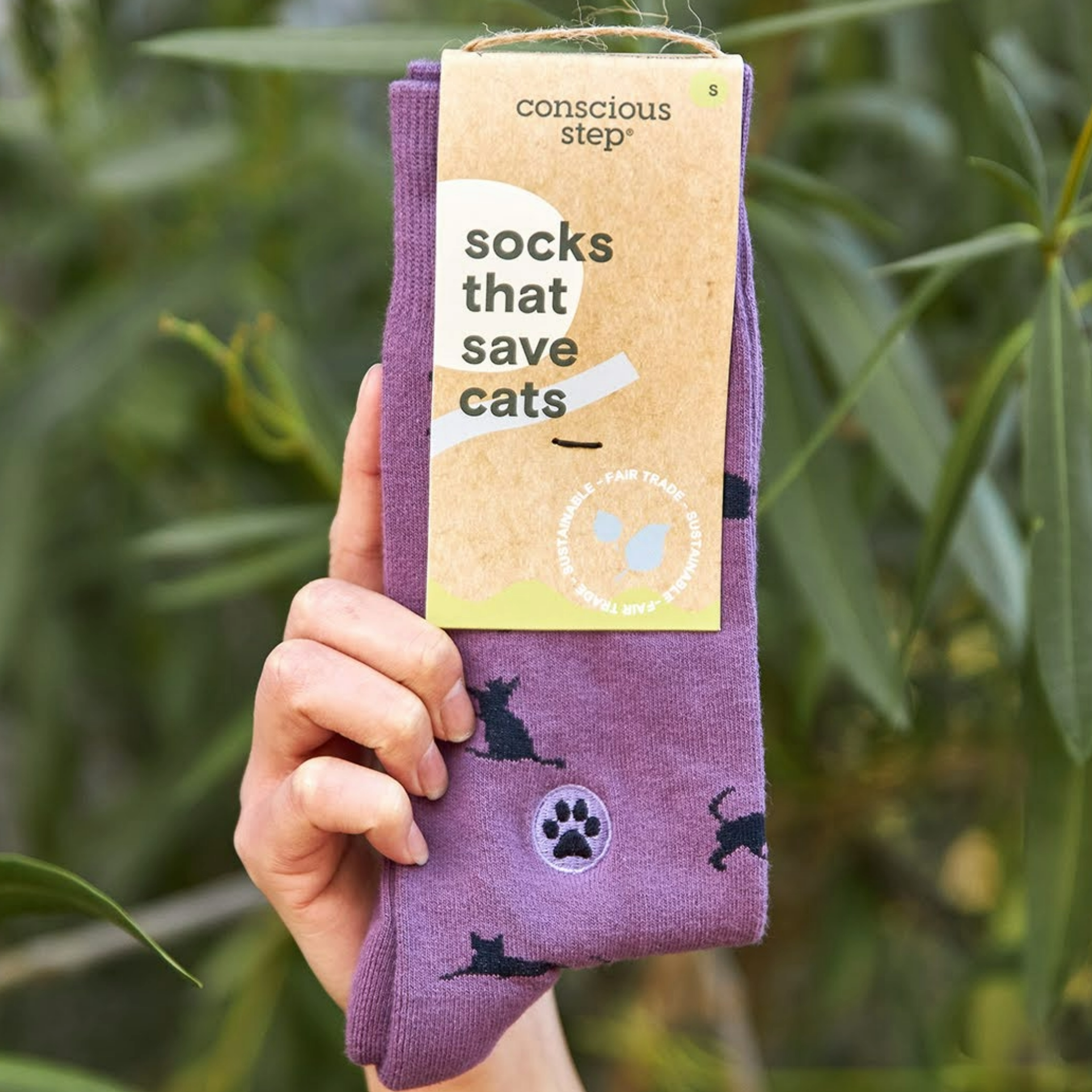 Close-up of light purple socks with navy blue cats and paw print embroidery, perfect for animal lovers
