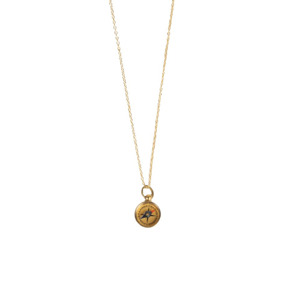 Close-up of handmade brass compass pendant necklace showing intricate detailing and functional compass