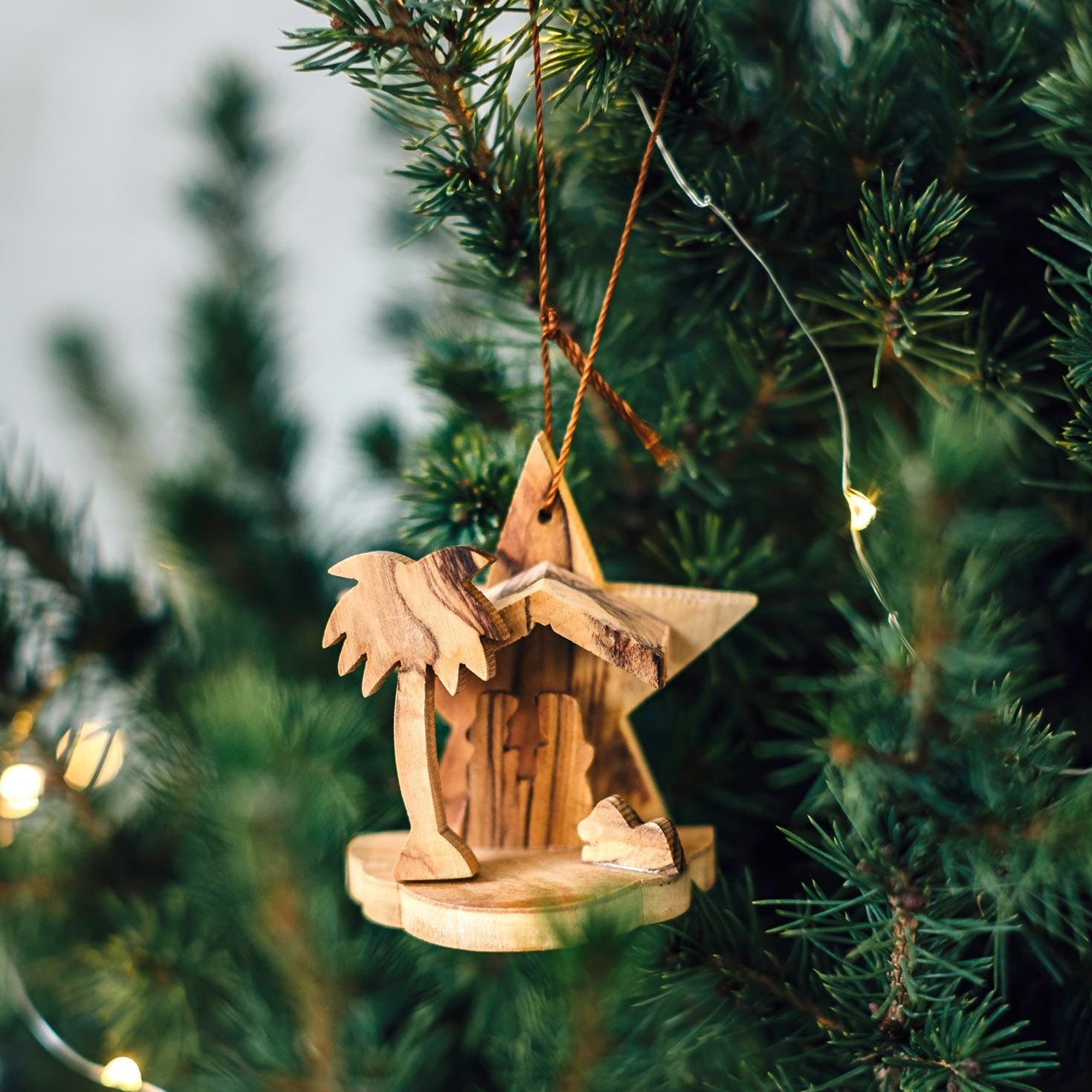 Close-up of hand-carved olive wood Christmas ornament showing detailed craftsmanship