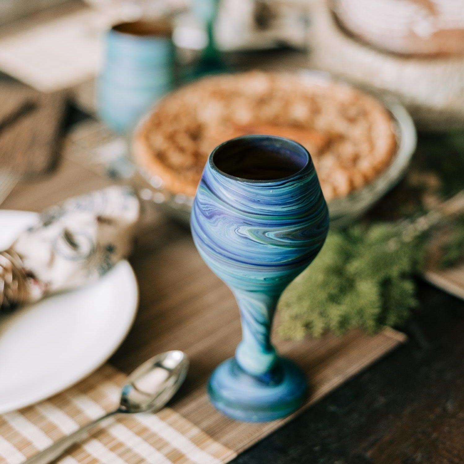 Close-up of a handblown Phoenician glass goblet with swirling colors