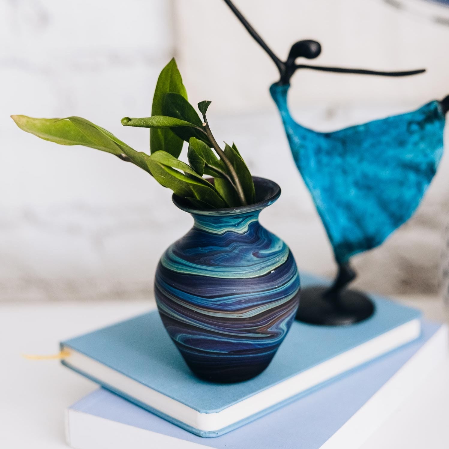 Side view of the handcrafted glass bud vase showcasing swirling blues and purples