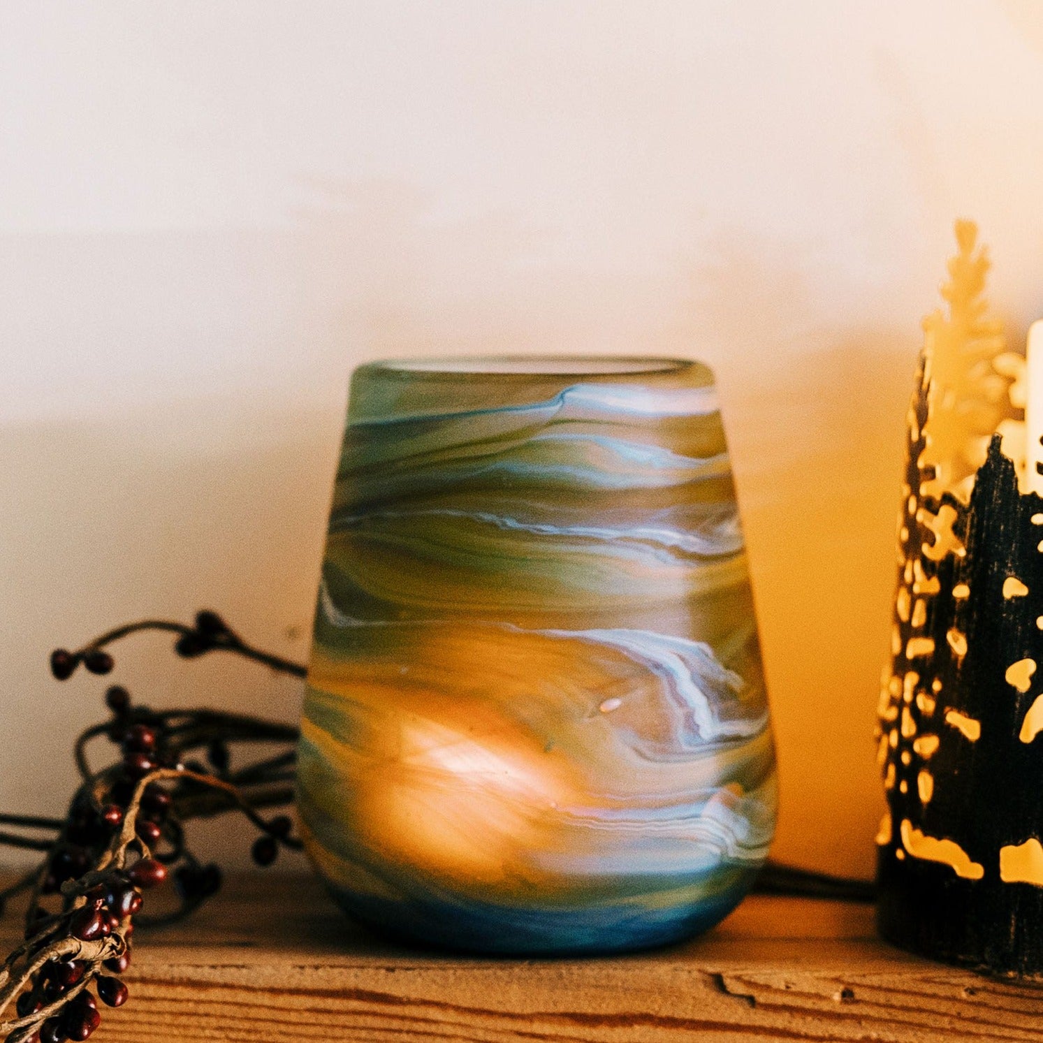 Close-up view of the handcrafted glass candleholder, highlighting its unique design and swirling colors.