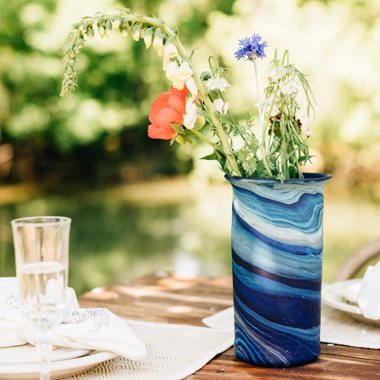 Elegant handblown glass vase showcasing vibrant colors and patterns from recycled glass.