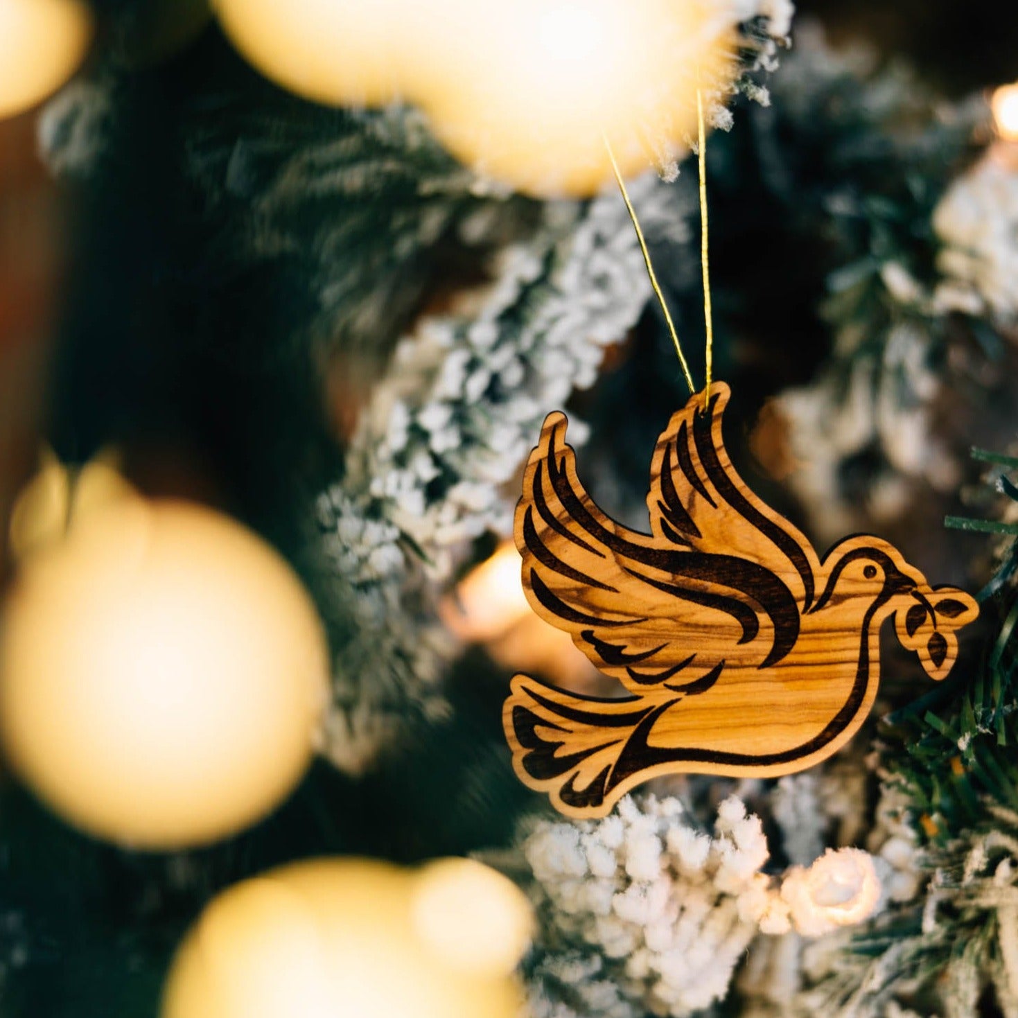 Close-up of handcrafted olive wood dove ornament showcasing intricate details.
