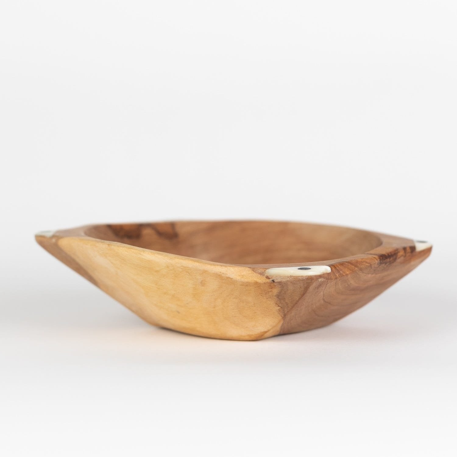 Artisan olive wood serving bowl showcasing beautiful grain and inlay, perfect for dinner parties.