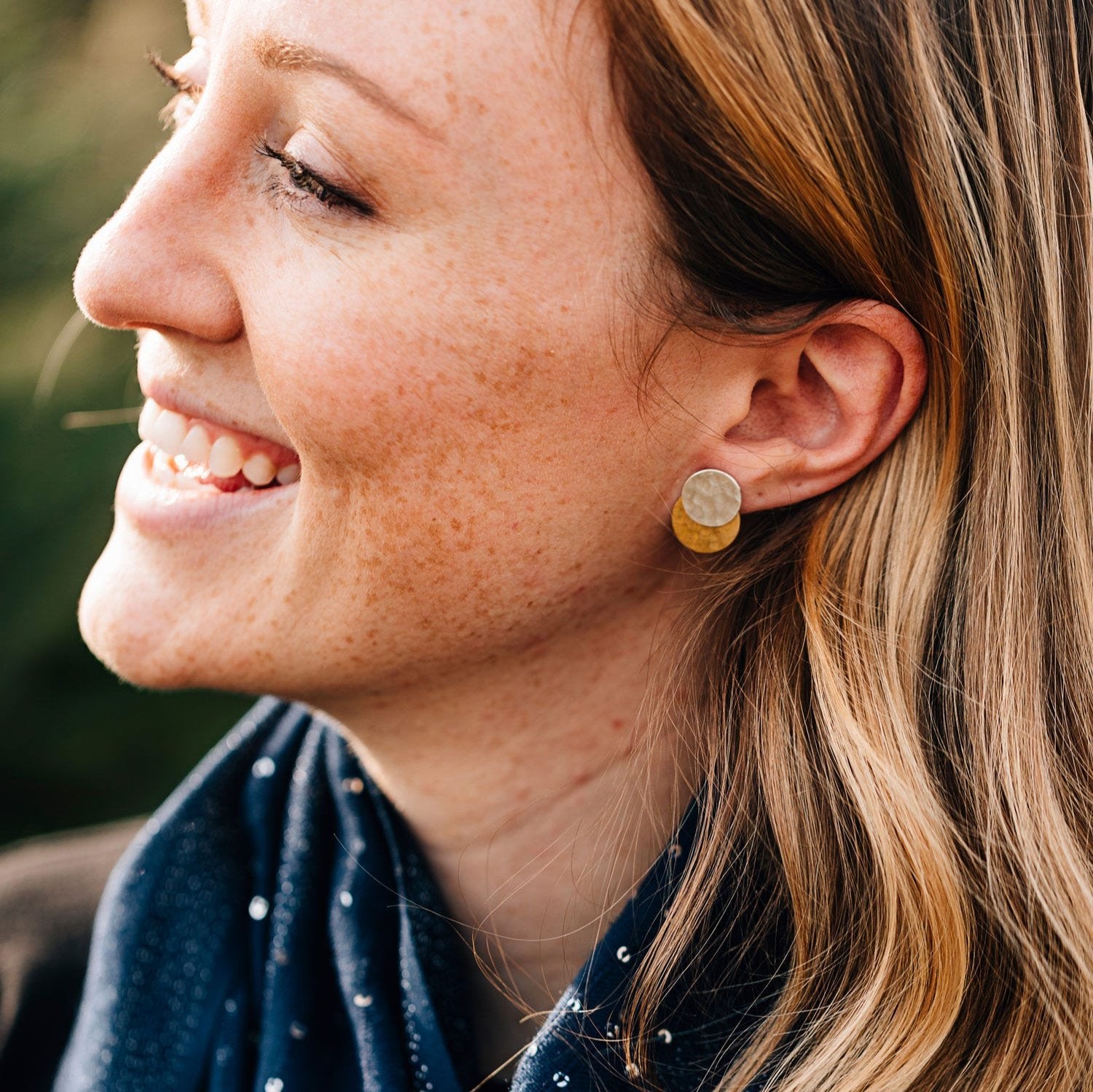 Close-up of handcrafted double disk earrings with gold and silver accents, ideal for any outfit.