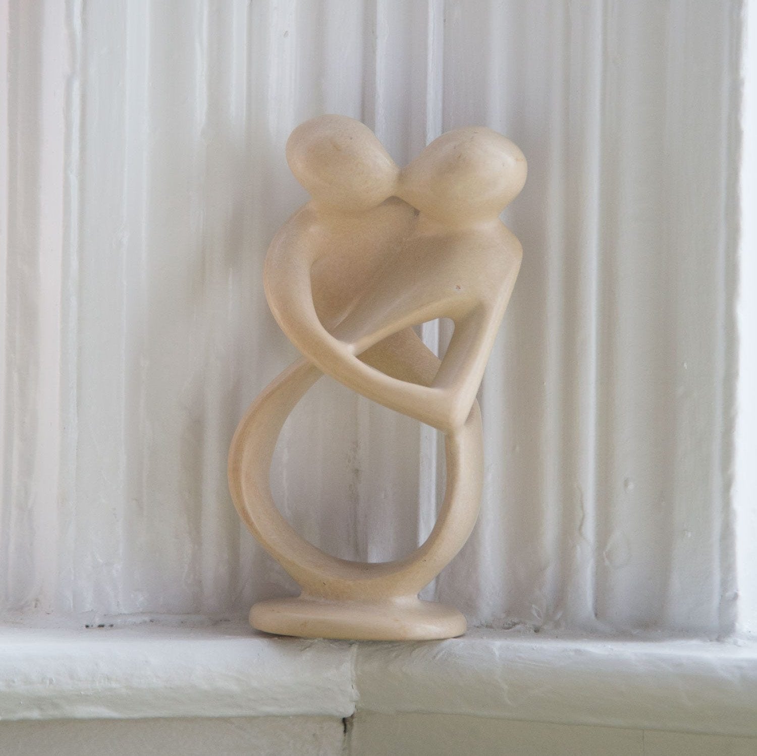 Close-up of the Timeless Embrace hand-carved sculpture showcasing intricate details and smooth finish.