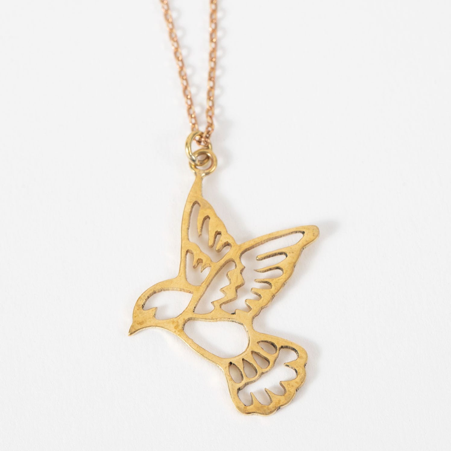 Close-up of the unique handmade peace necklace displaying its intricate design and brass finish.