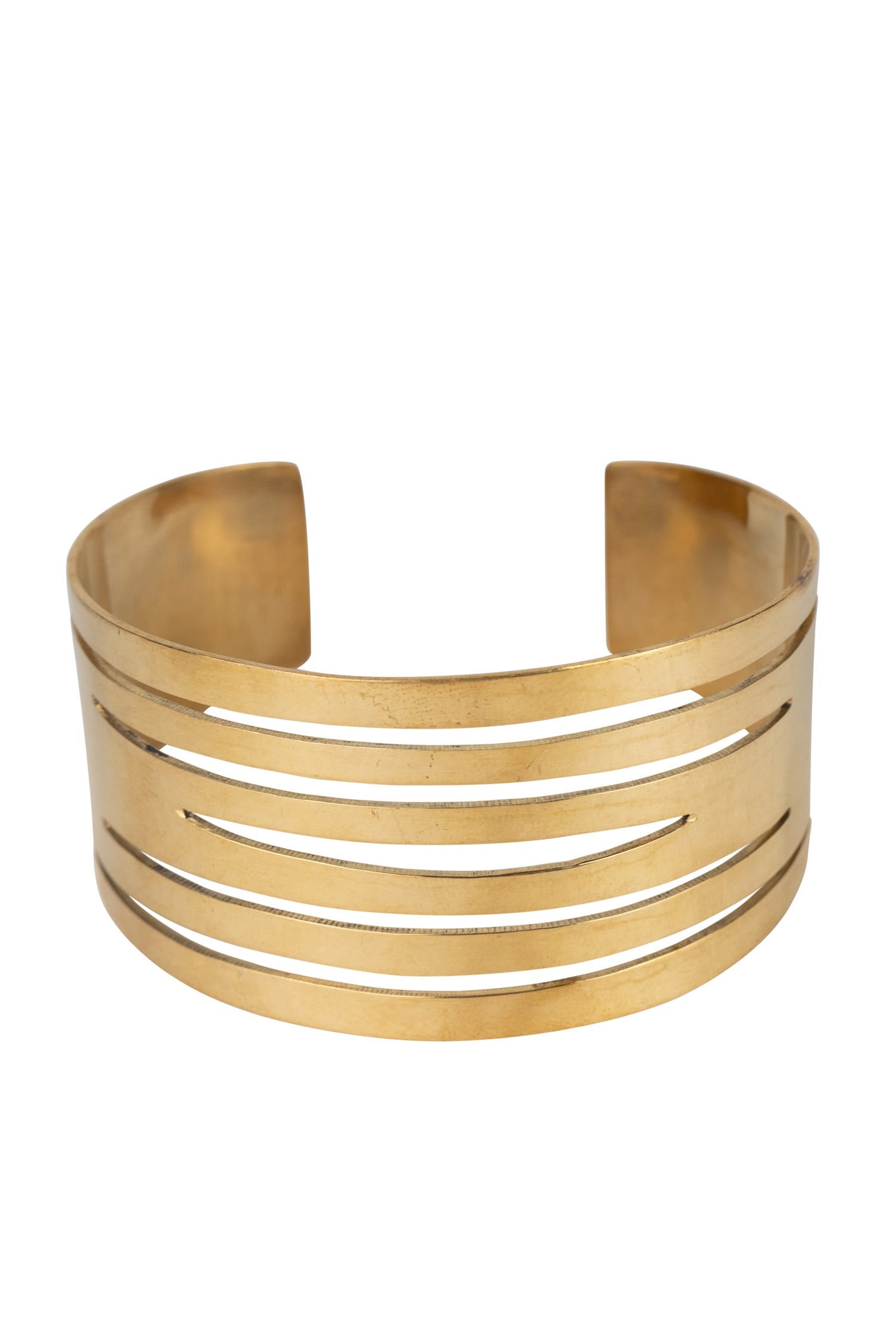 Overhead shot of brass jewelry cuff styled over linen sleeve