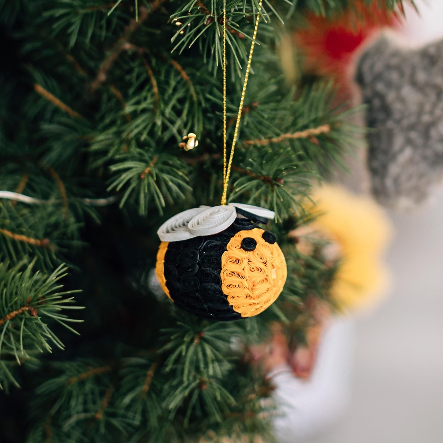 Close-up of a handmade quilled bee ornament with detailed paper coiling