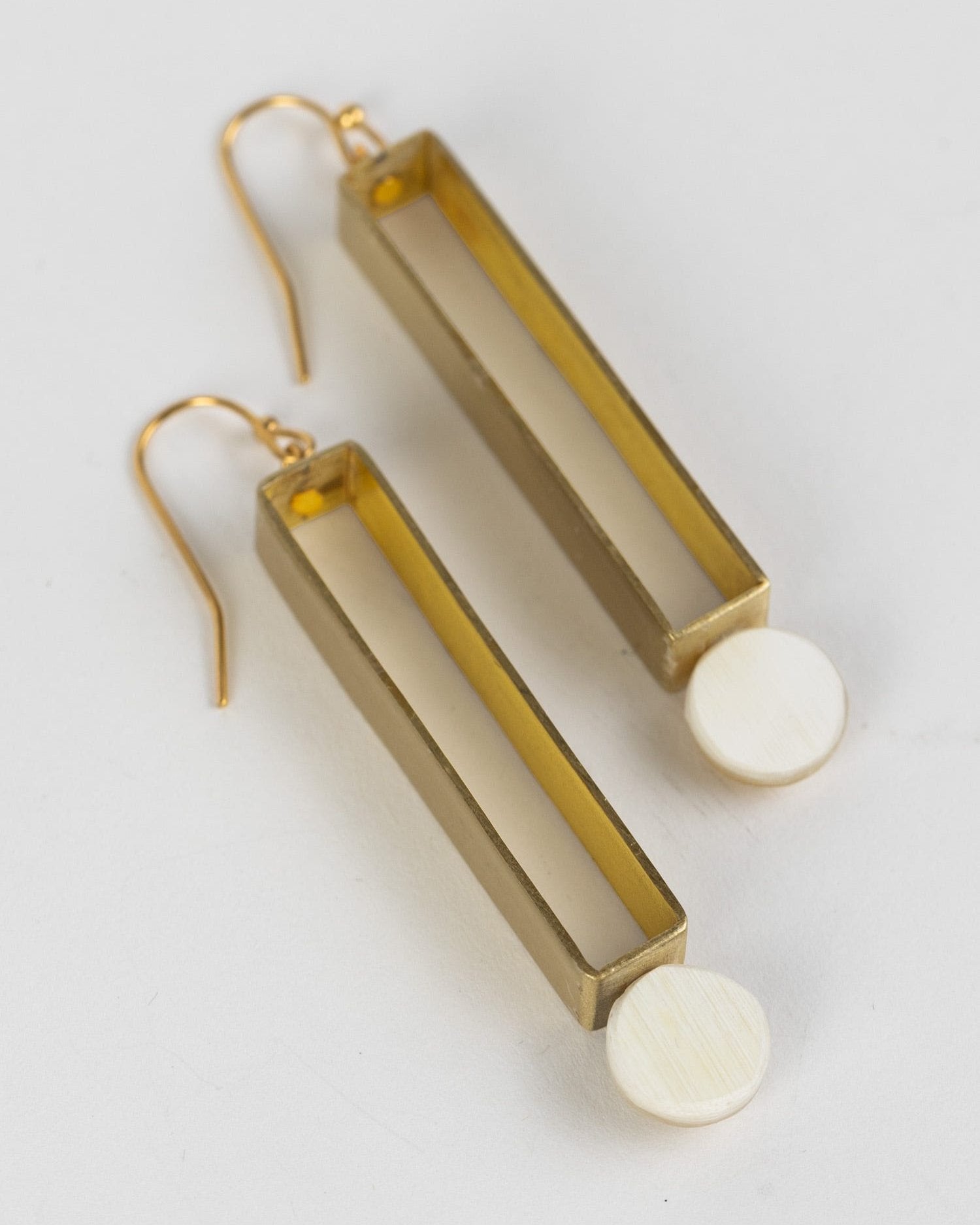 Brass exclamation point earrings worn by a model, highlighting their unique design.