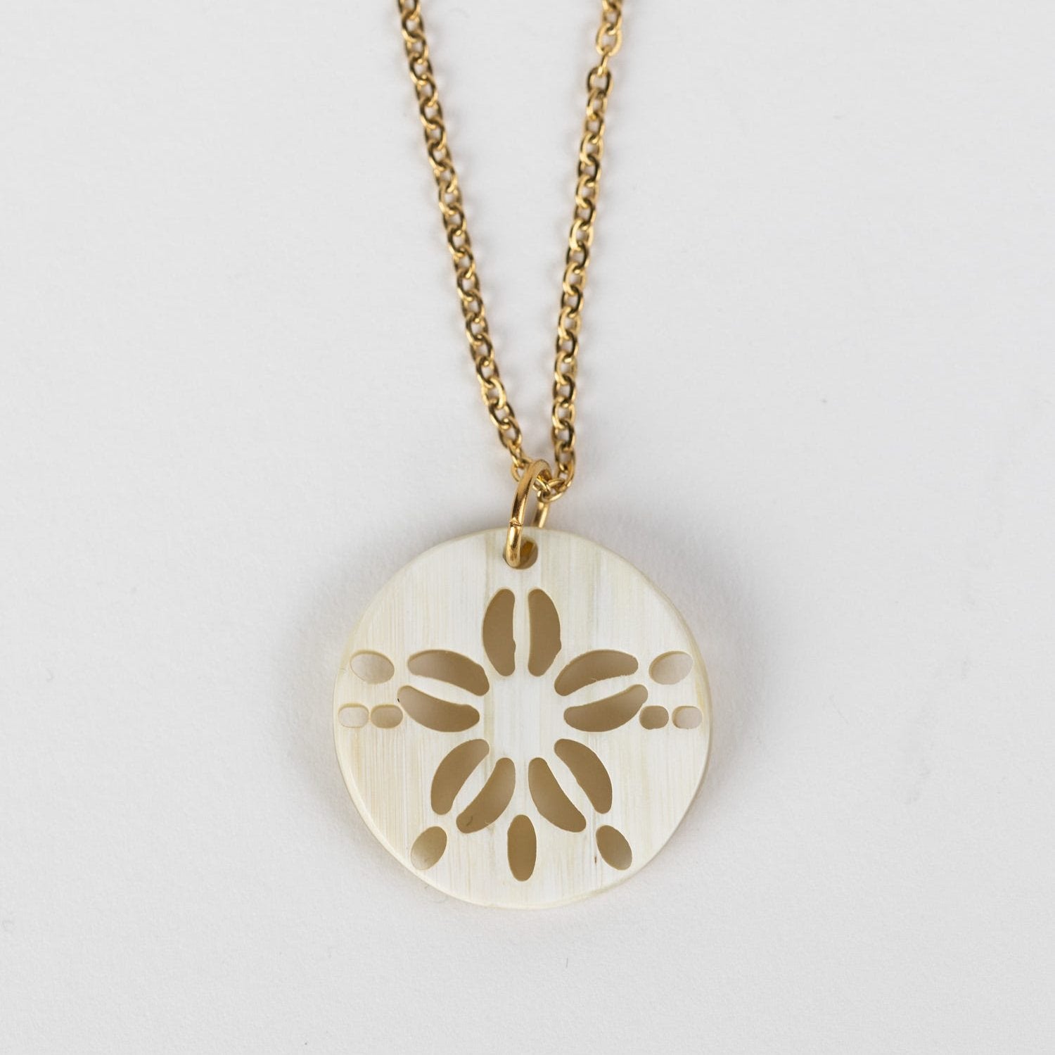 Close-up of the artisan crafted sand dollar pendant necklace showing details.