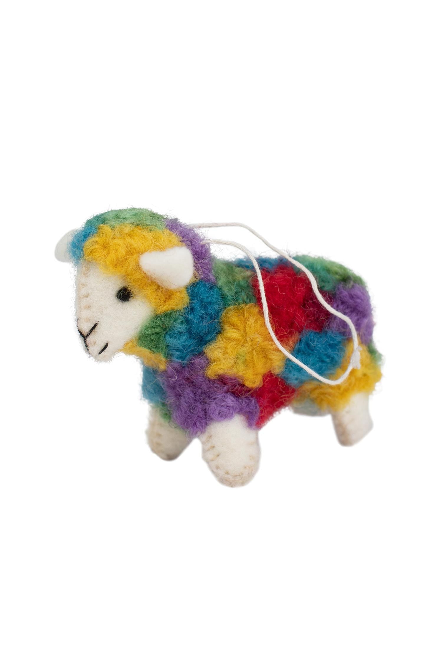 Vibrant artisan sheep ornament displayed on a rustic shelf, highlighting its colorful design.