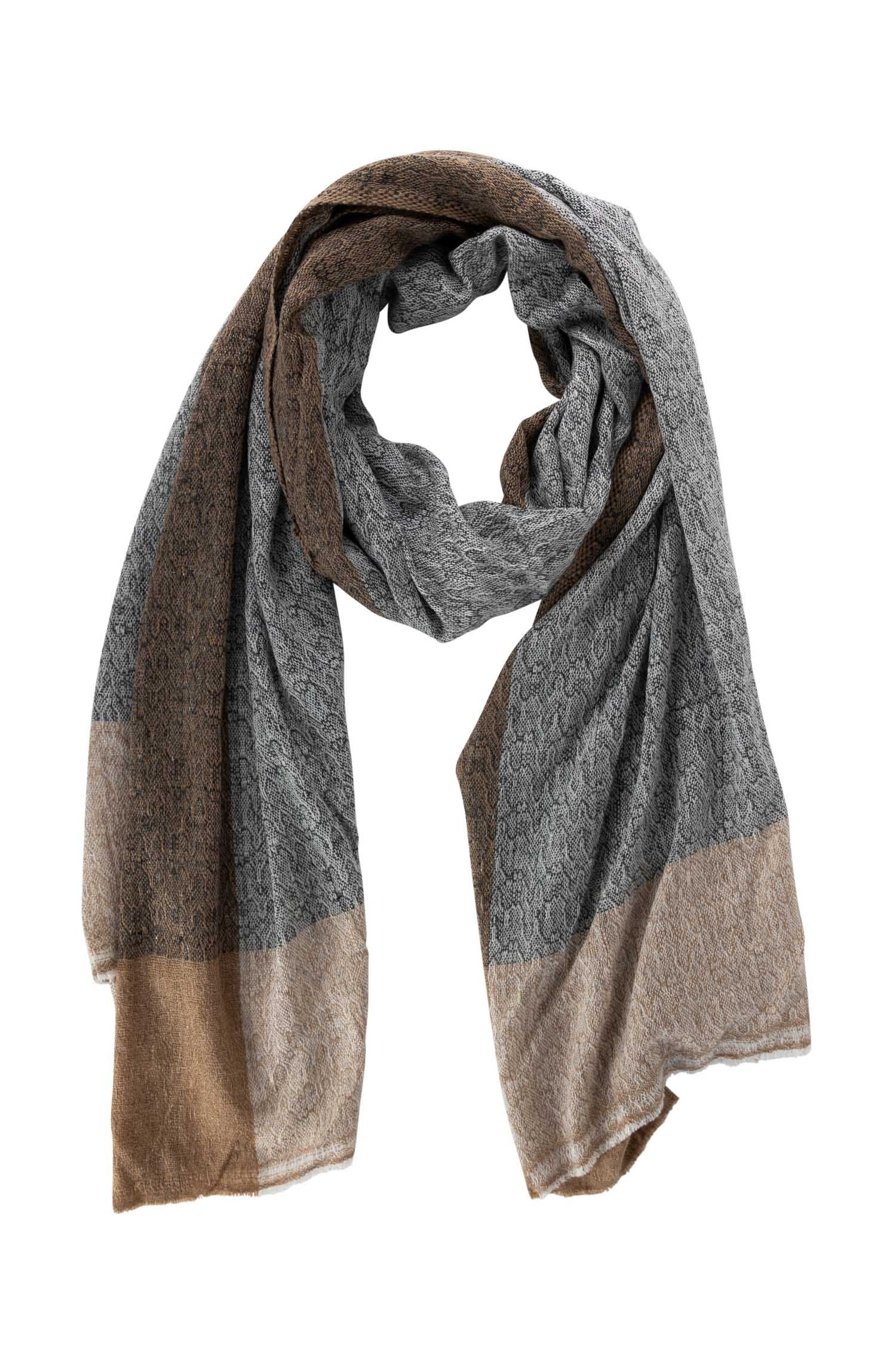 Artisan handwoven wool shawl draped elegantly on a chair, showcasing its soft texture.