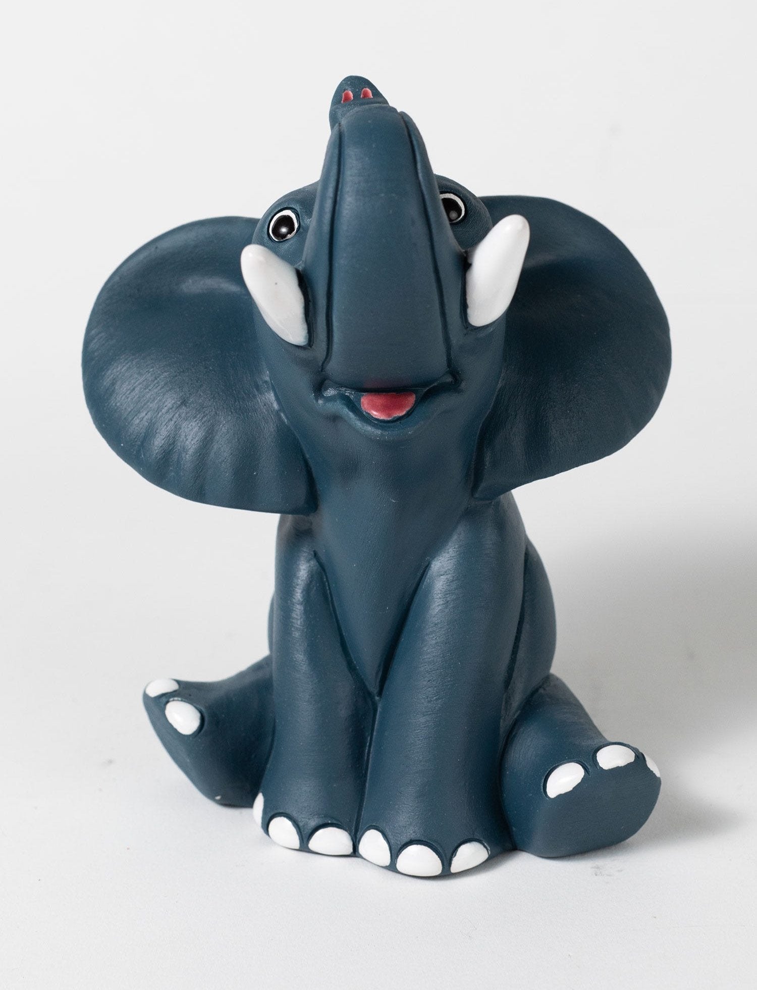 Whimsical ceramic elephant eyeglass holder on a bedside table