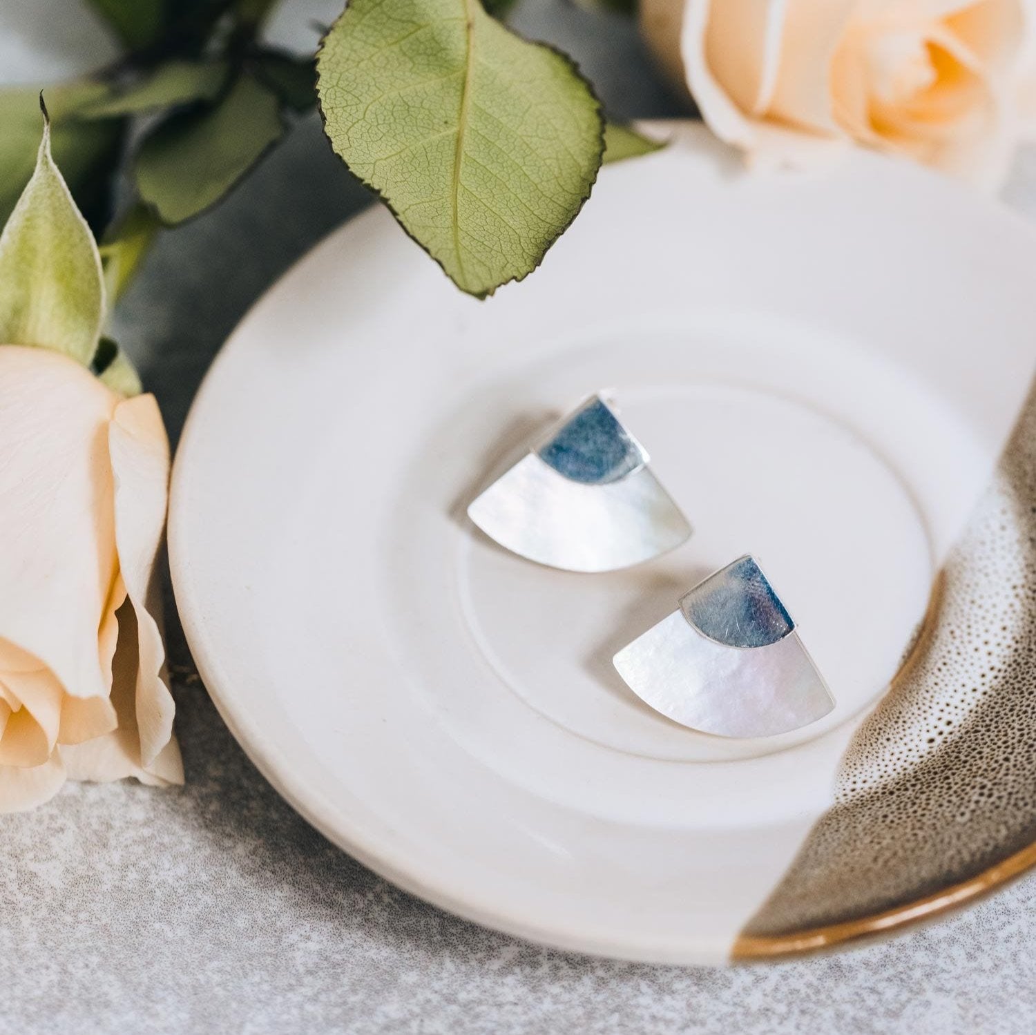 Elegant sterling silver mother of pearl fan earrings showcasing their intricate design from the side.
