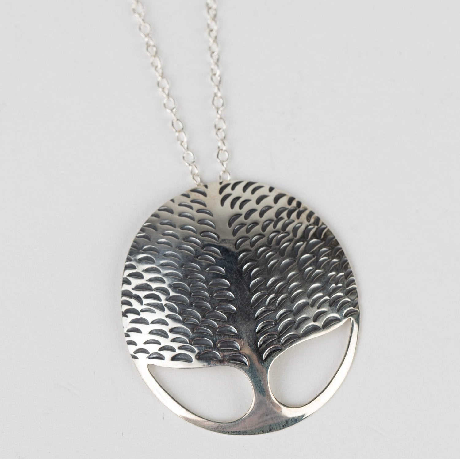 Close-up of sterling silver tree pendant necklace showing detailed craftsmanship