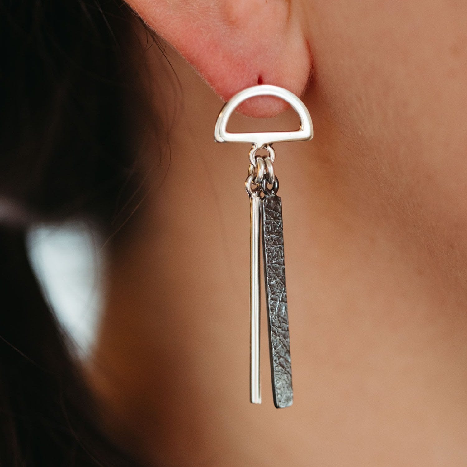 Close-up of handcrafted sterling silver earrings with intricate designs.