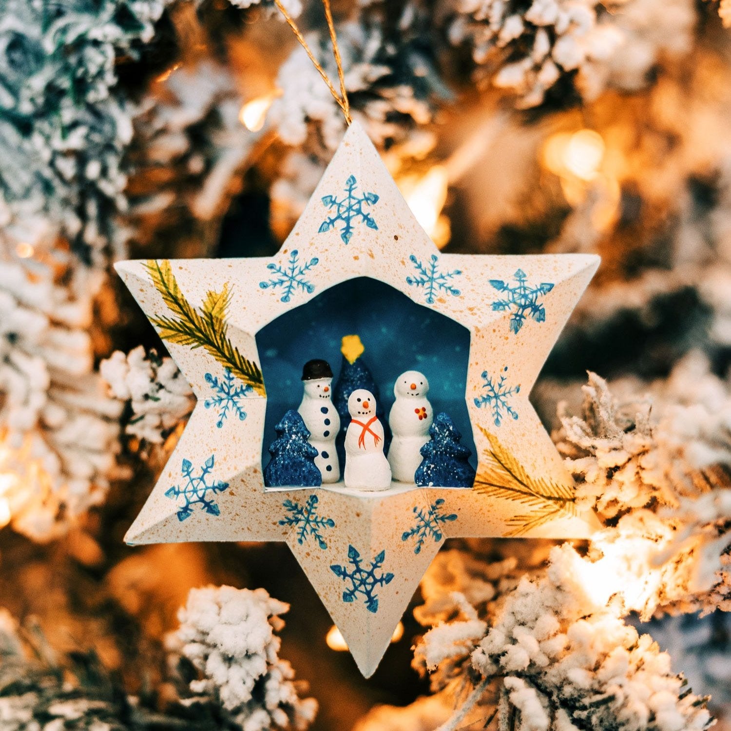 Charming snowman family star ornament showcasing the happy snowmen with aqua snowflakes.