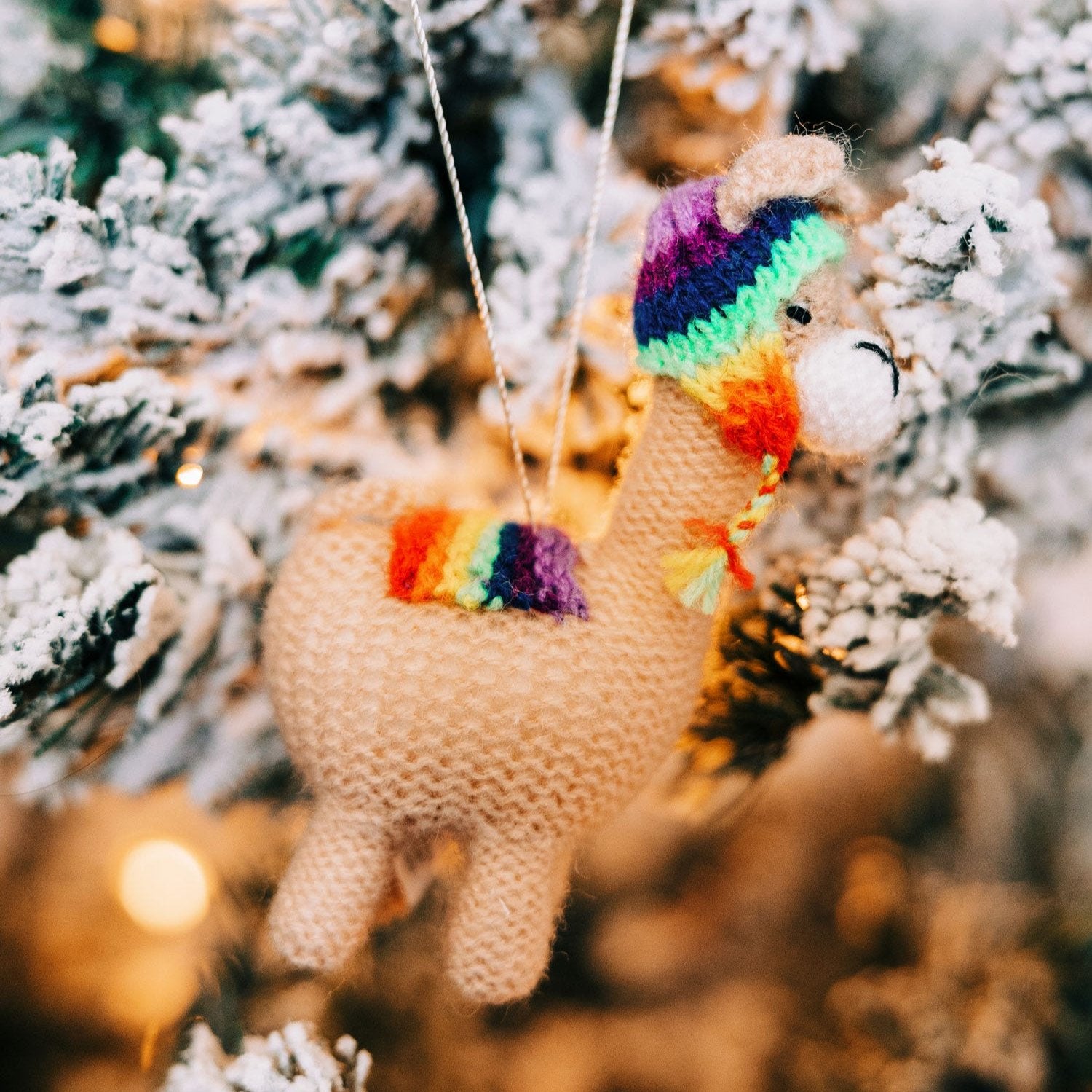 Llama love ornament with rainbow hat and saddle blanket, capturing the festive spirit.