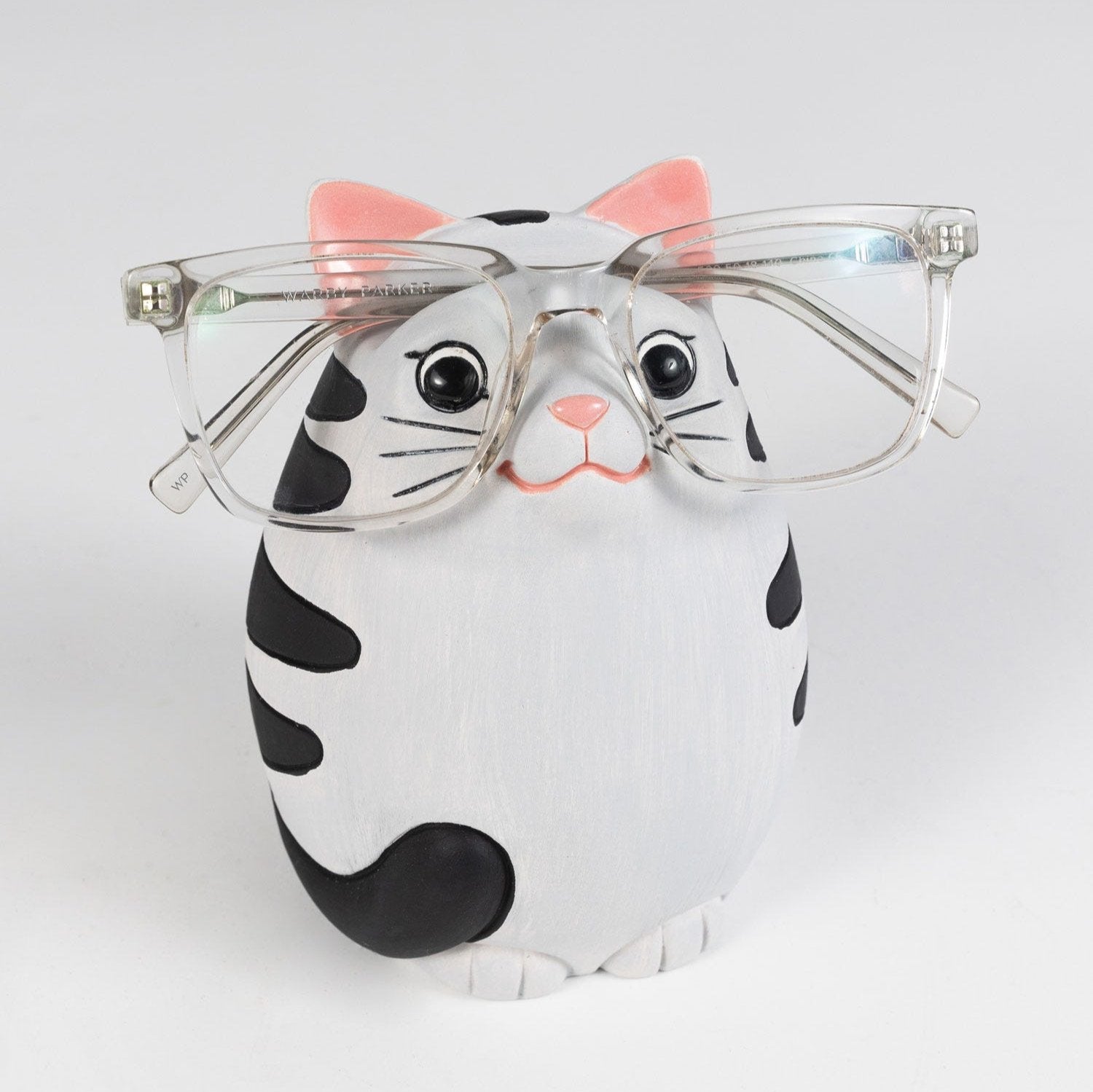 Close-up of the ceramic cat eyeglass holder showing grooves for glasses