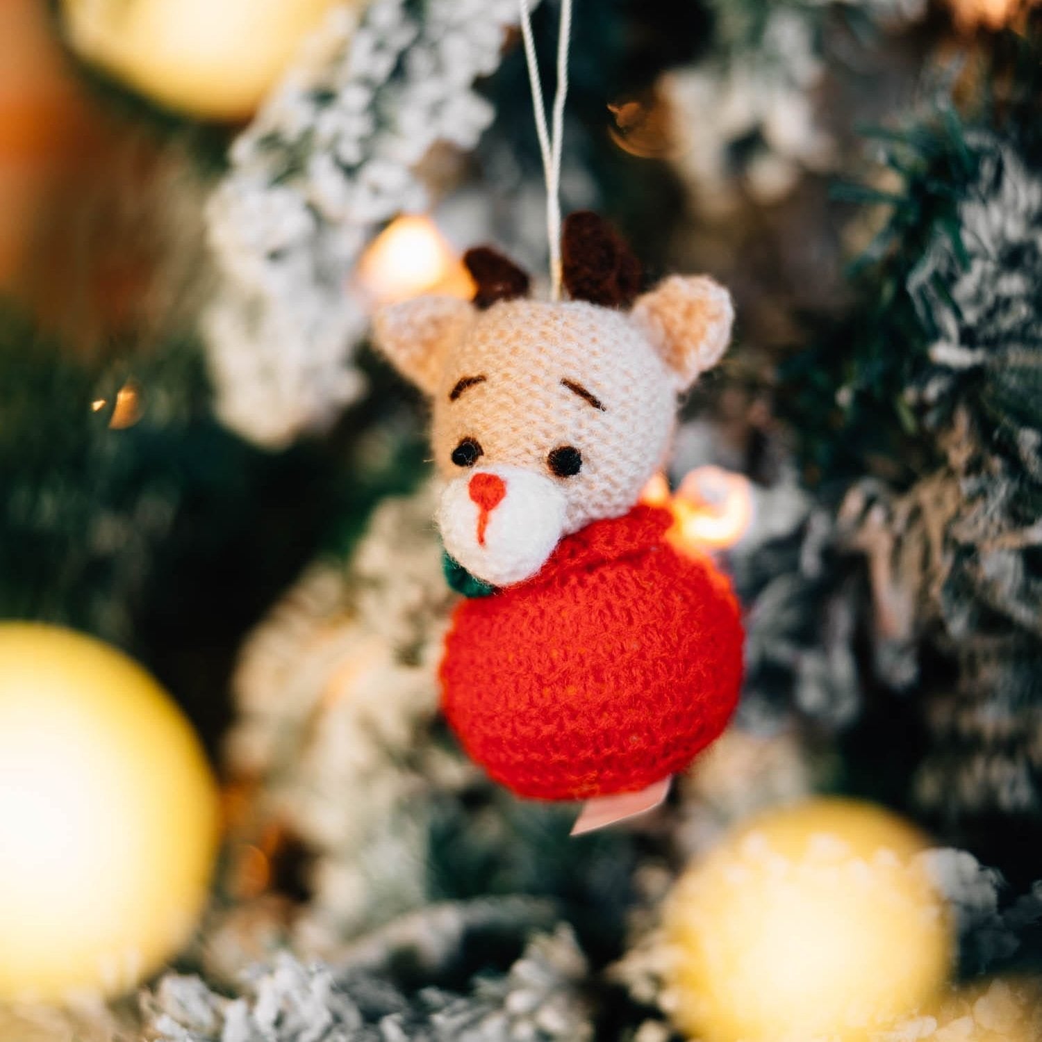 Handmade crochet reindeer ornament hanging on Christmas tree for holiday decor