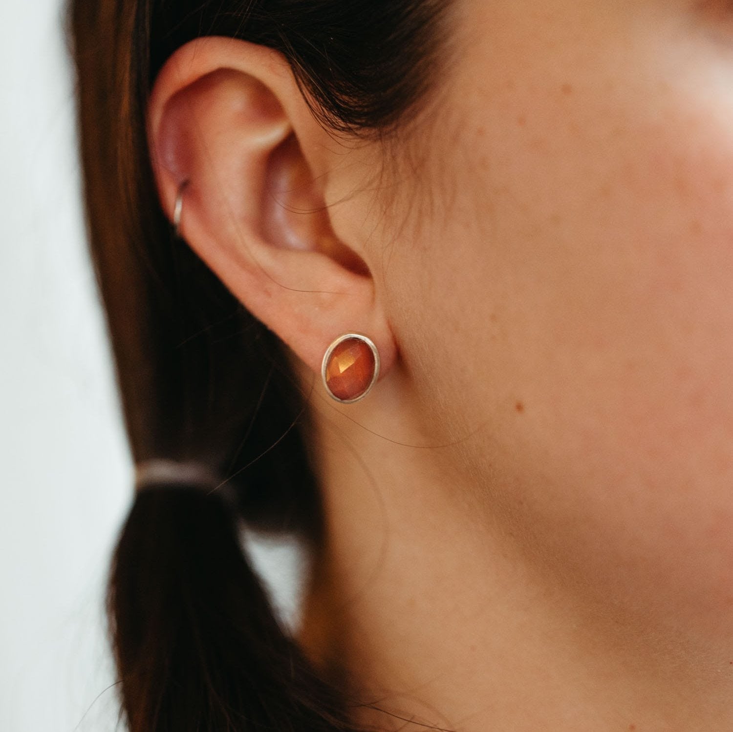 Close-up of cherry quartz stud earrings showing sterling silver settings