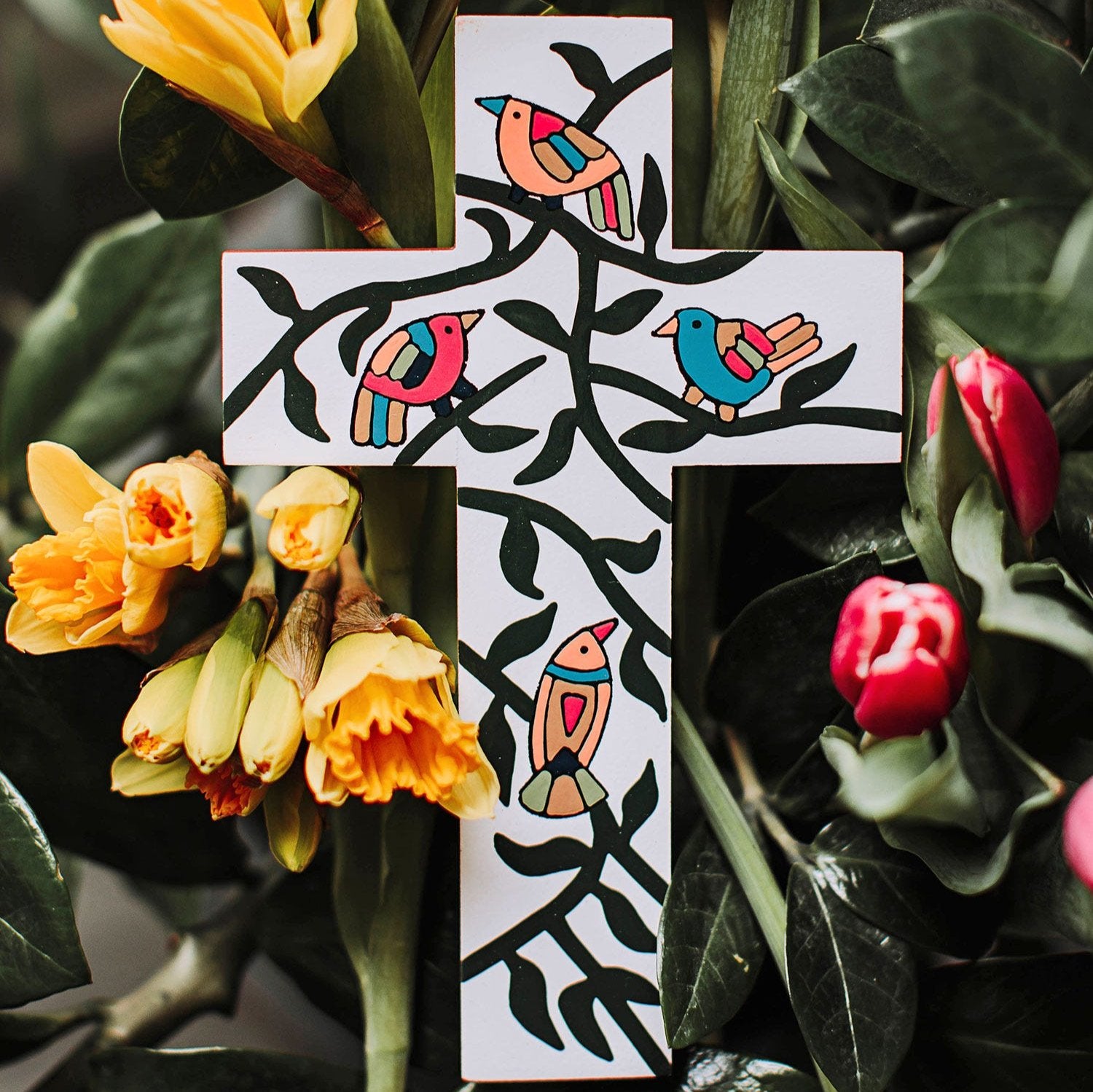 Front view of the hand-painted cross featuring bright folk art designs.