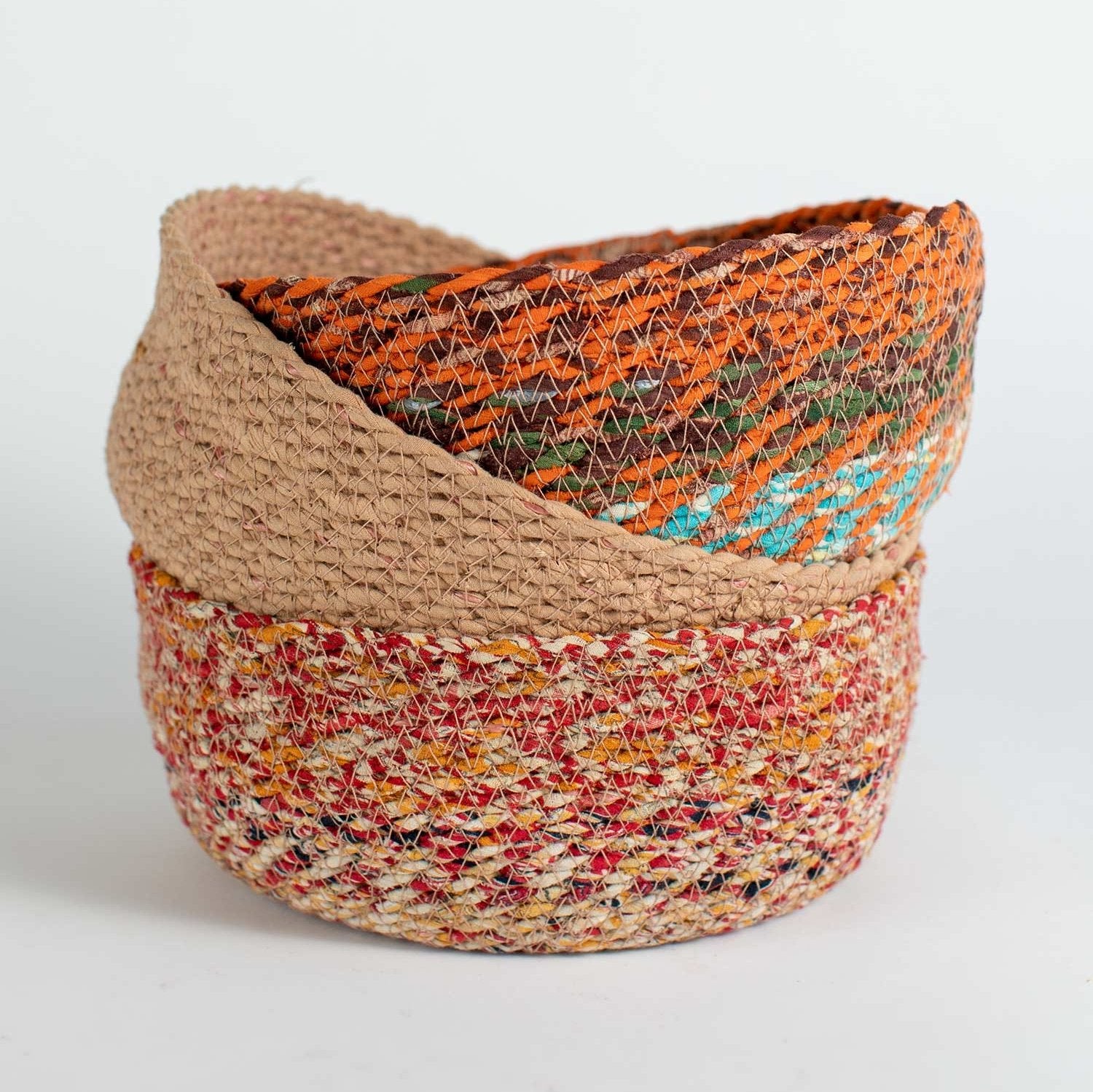Recycled fabric artisan woven basket displayed in a modern living room setting.