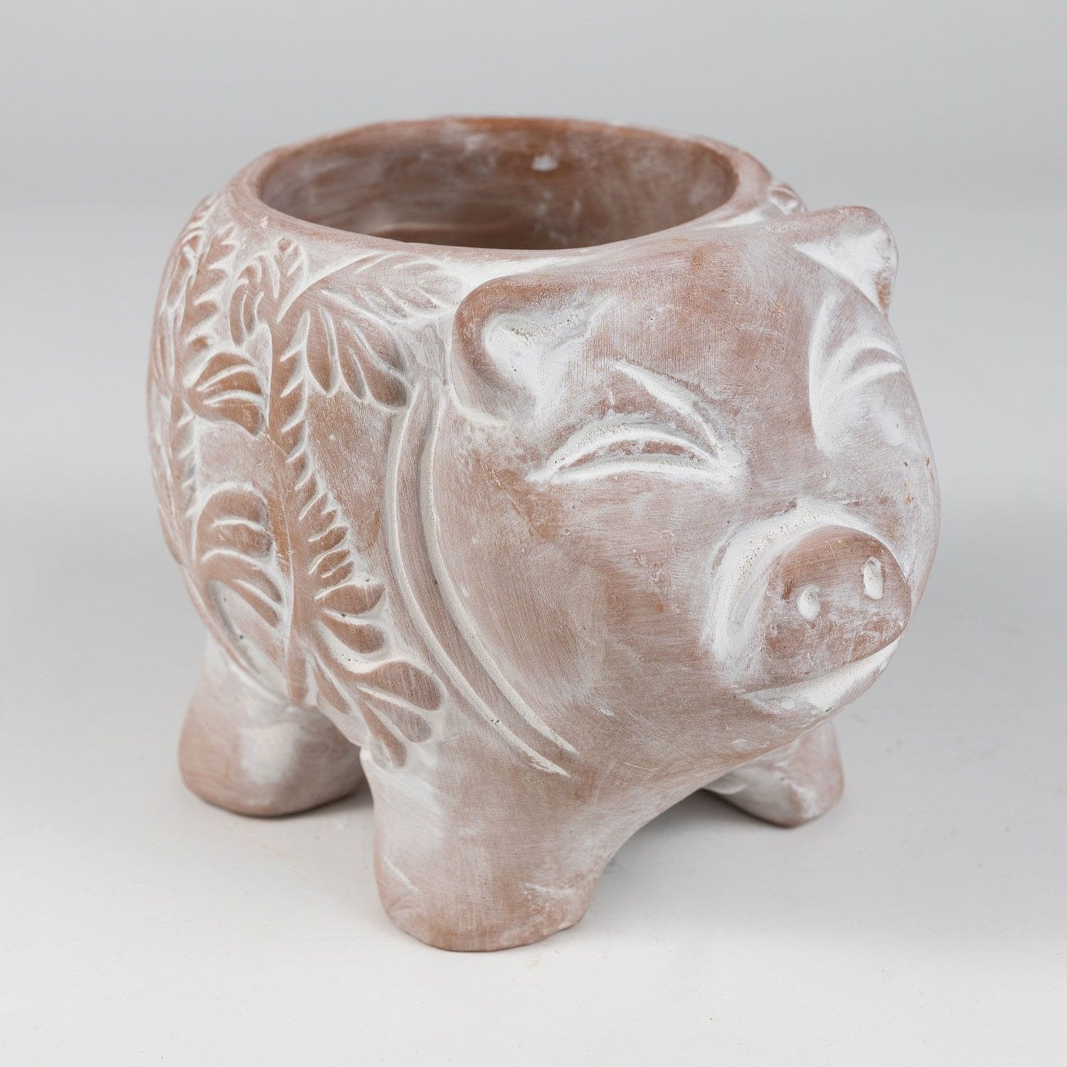 Front view of handcrafted Happy Pig terracotta planter with indoor plant