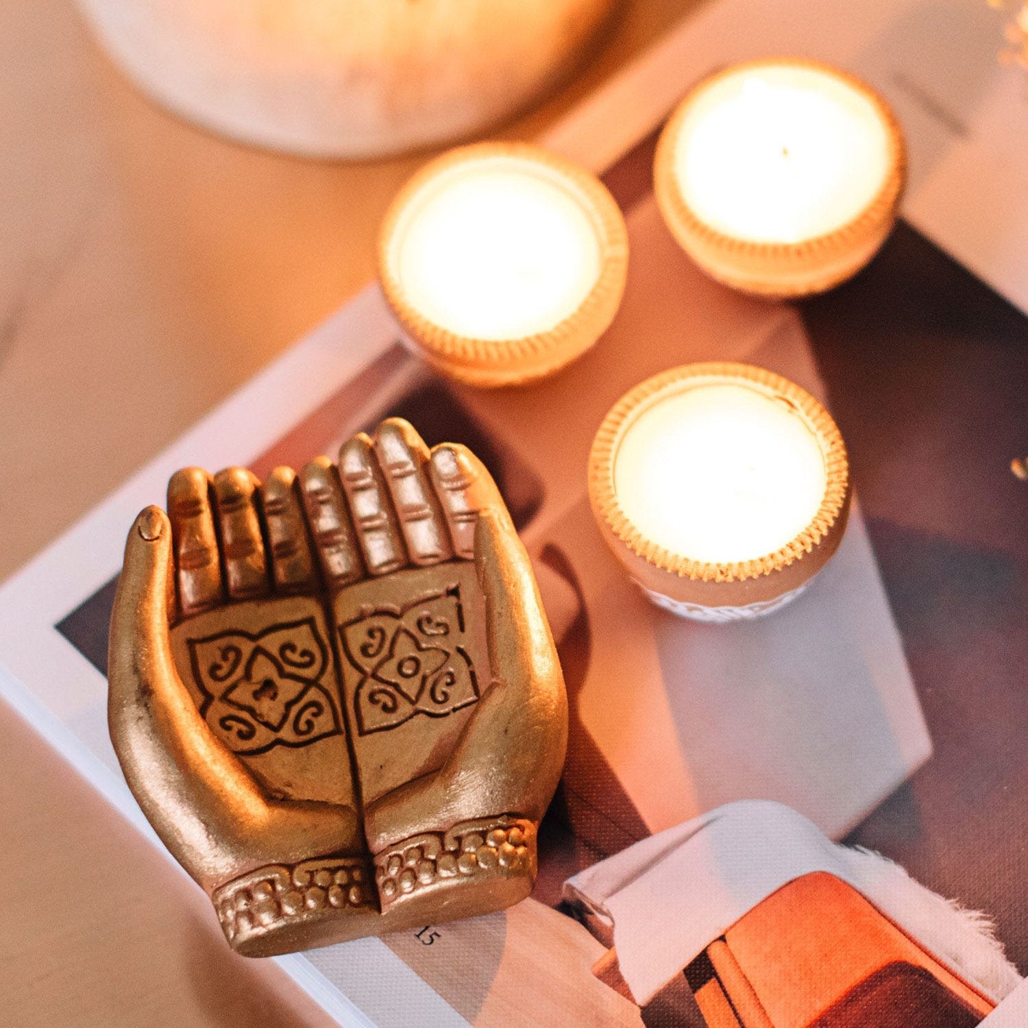 Close-up of gold-painted hand candleholder showing 'mudra' gesture for decorative home decor