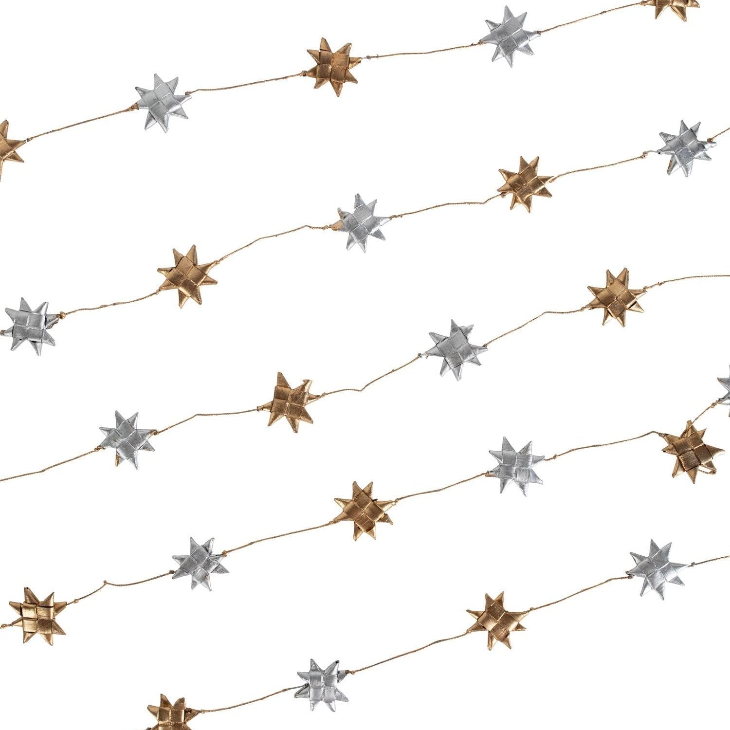 Close-up of silver and gold star garland draped across a Christmas tree branch