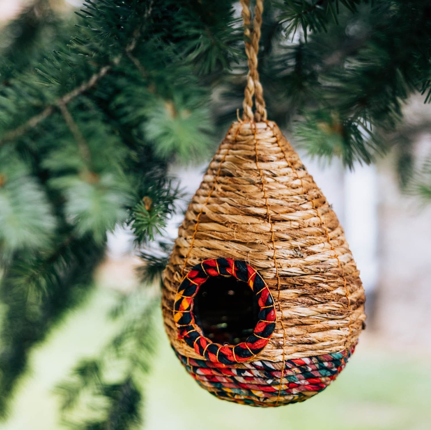 Eco-friendly teardrop birdhouse made from recycled materials, showcasing vibrant colors and textures.