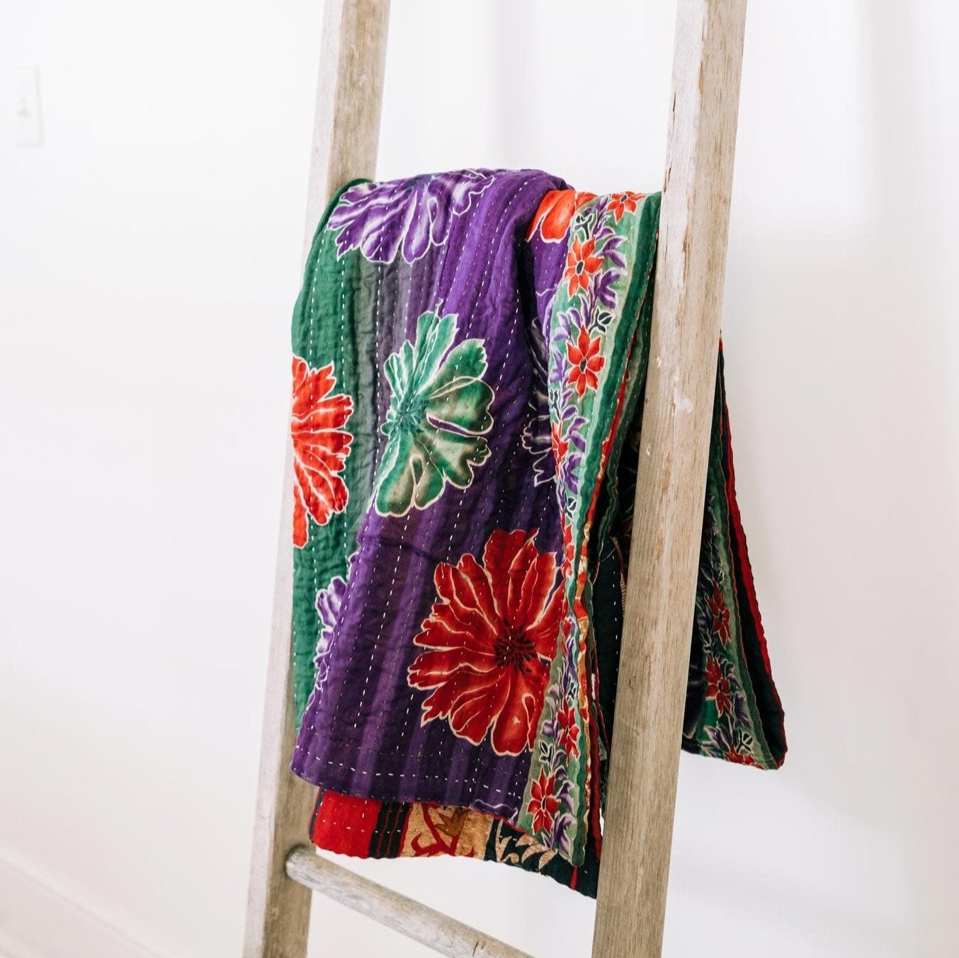 Handmade eco friendly wedding gift blanket made from recycled sari fabrics draped over a sofa