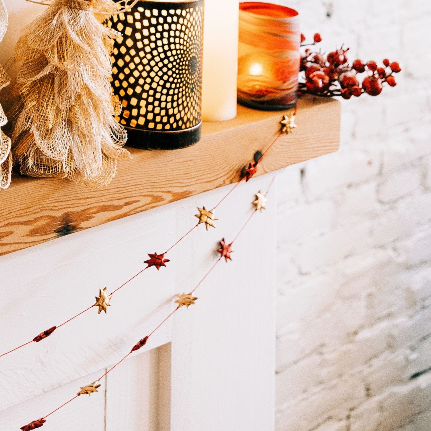 Close-up of red and gold palm leaf stars woven into Christmas garland, perfect for holiday decorating