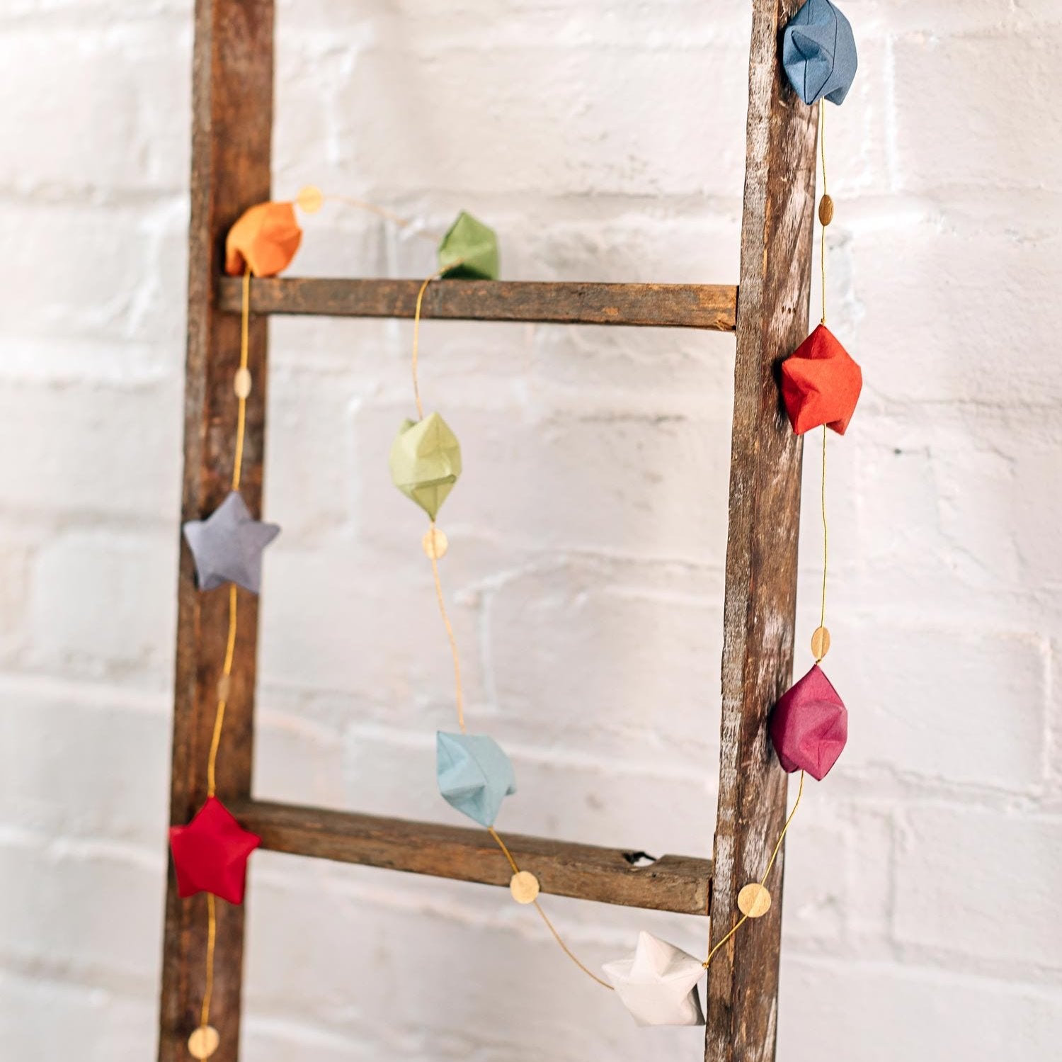Close-up of rainbow star garland made from eco-friendly paper, hanging indoors