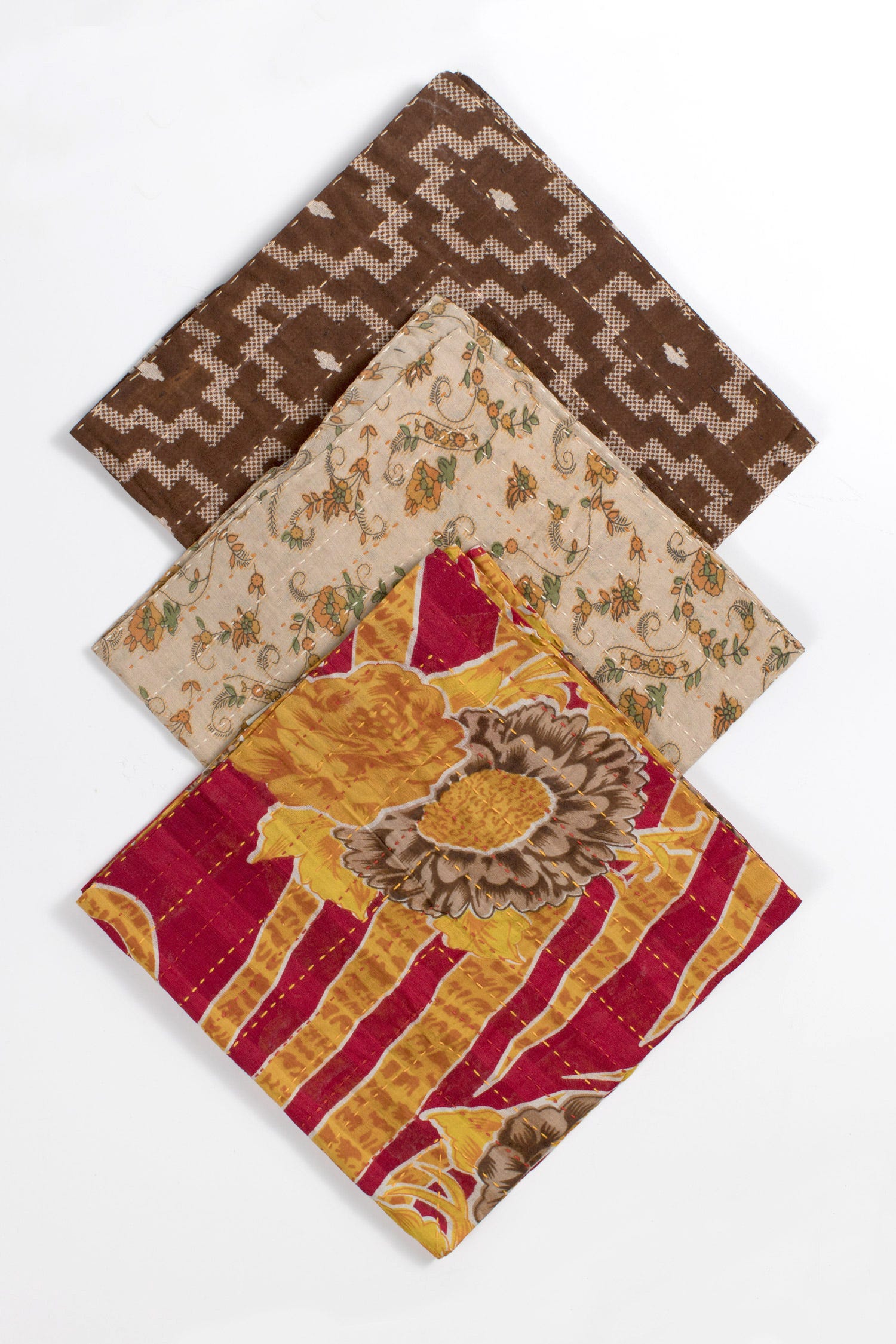 Close-up of vibrant recycled sari napkin displaying intricate handmade stitching