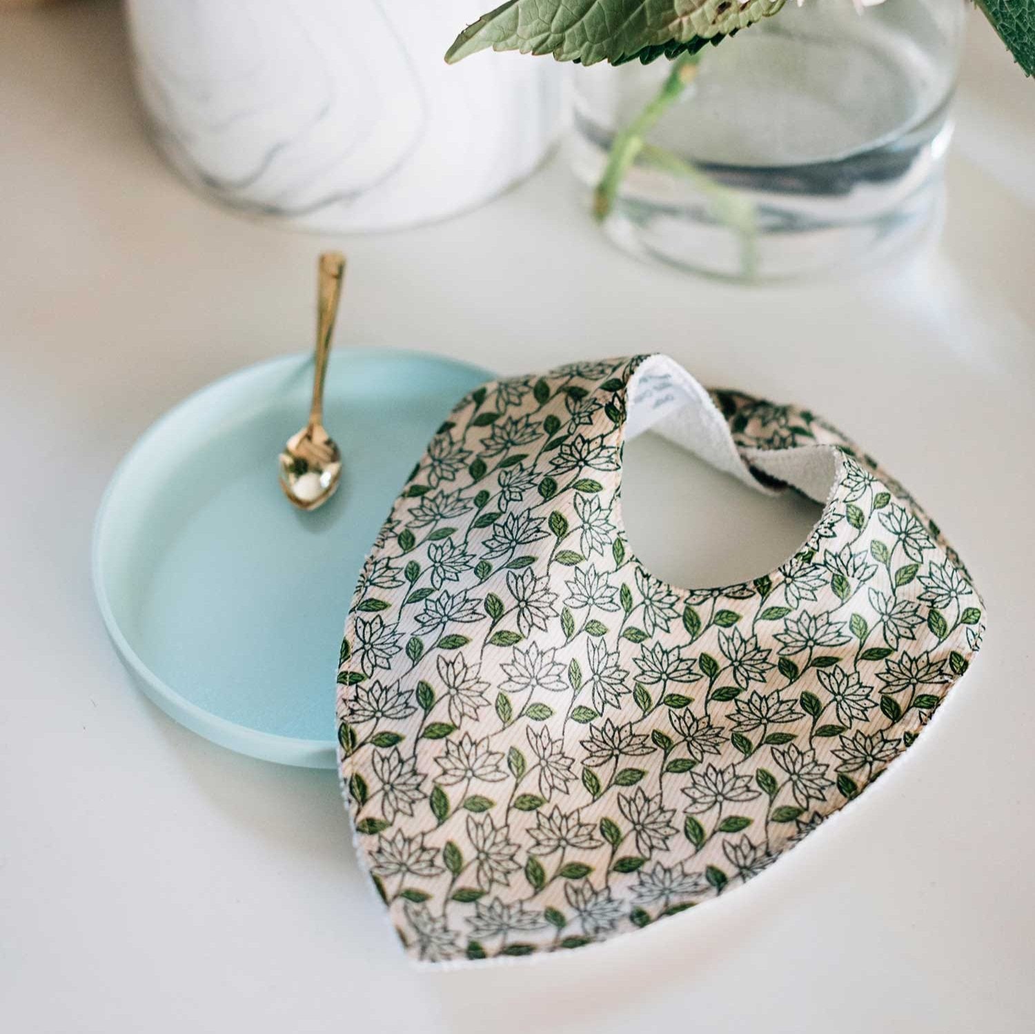 Bright upcycled sari baby bib with adjustable snaps on a baby model