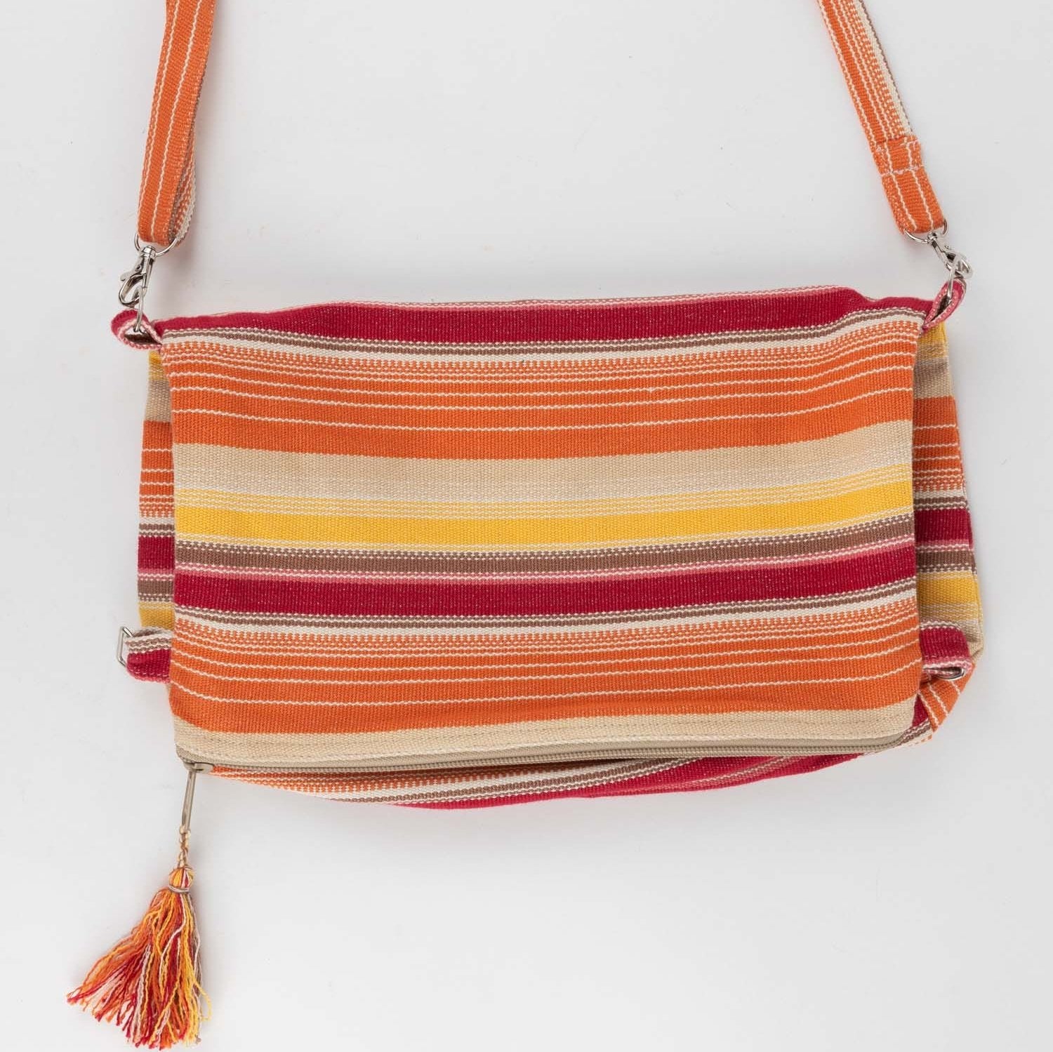Side view of sunset-colored handcrafted shoulder bag with tassel details