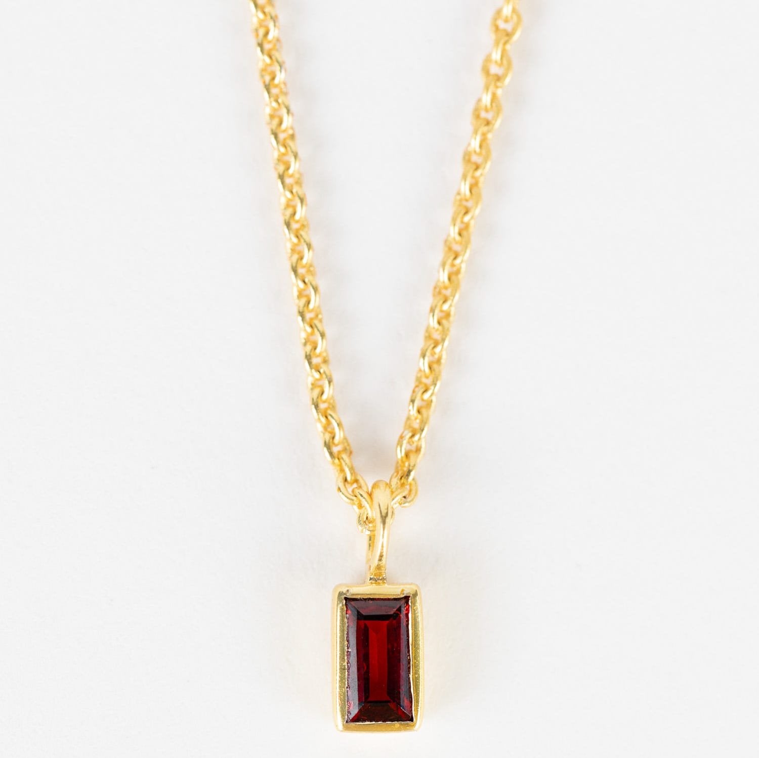 Close-up of handcrafted garnet gold necklace showcasing red gemstones and fine craftsmanship