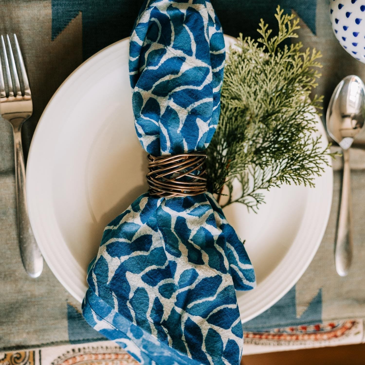 Breezy Cotton Napkin Set on a dining table, showcasing its vibrant hand-printed design