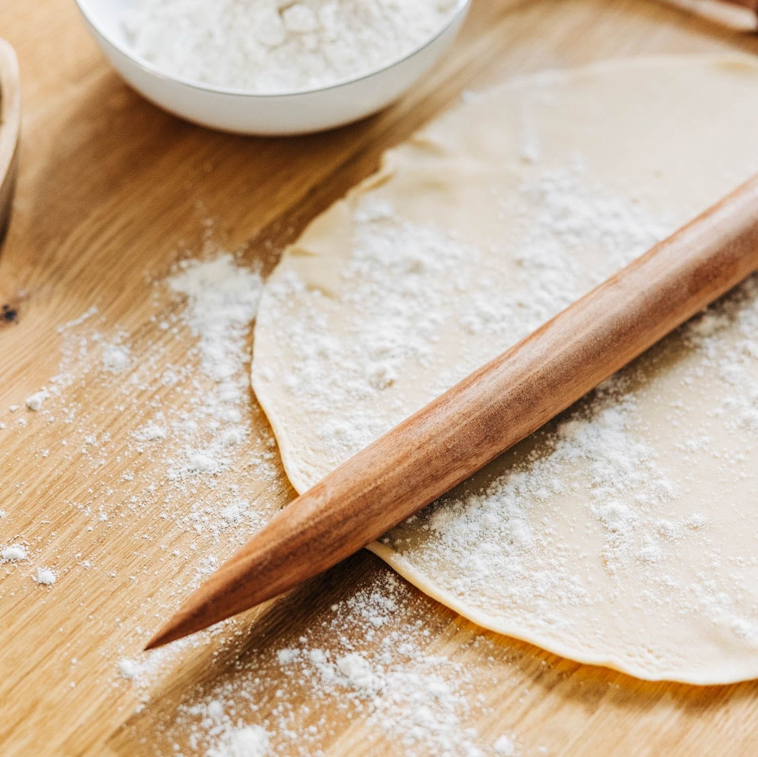 Artisan French tapered rolling pin on a marble countertop, showcasing its smooth finish and tapered design.