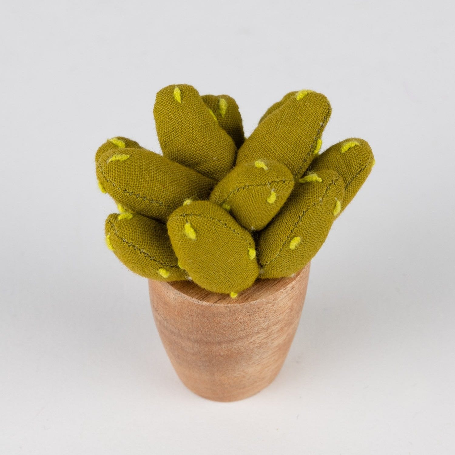 Handmade mini prickly pear cactus on a desk, showcasing its vibrant colors and unique design.